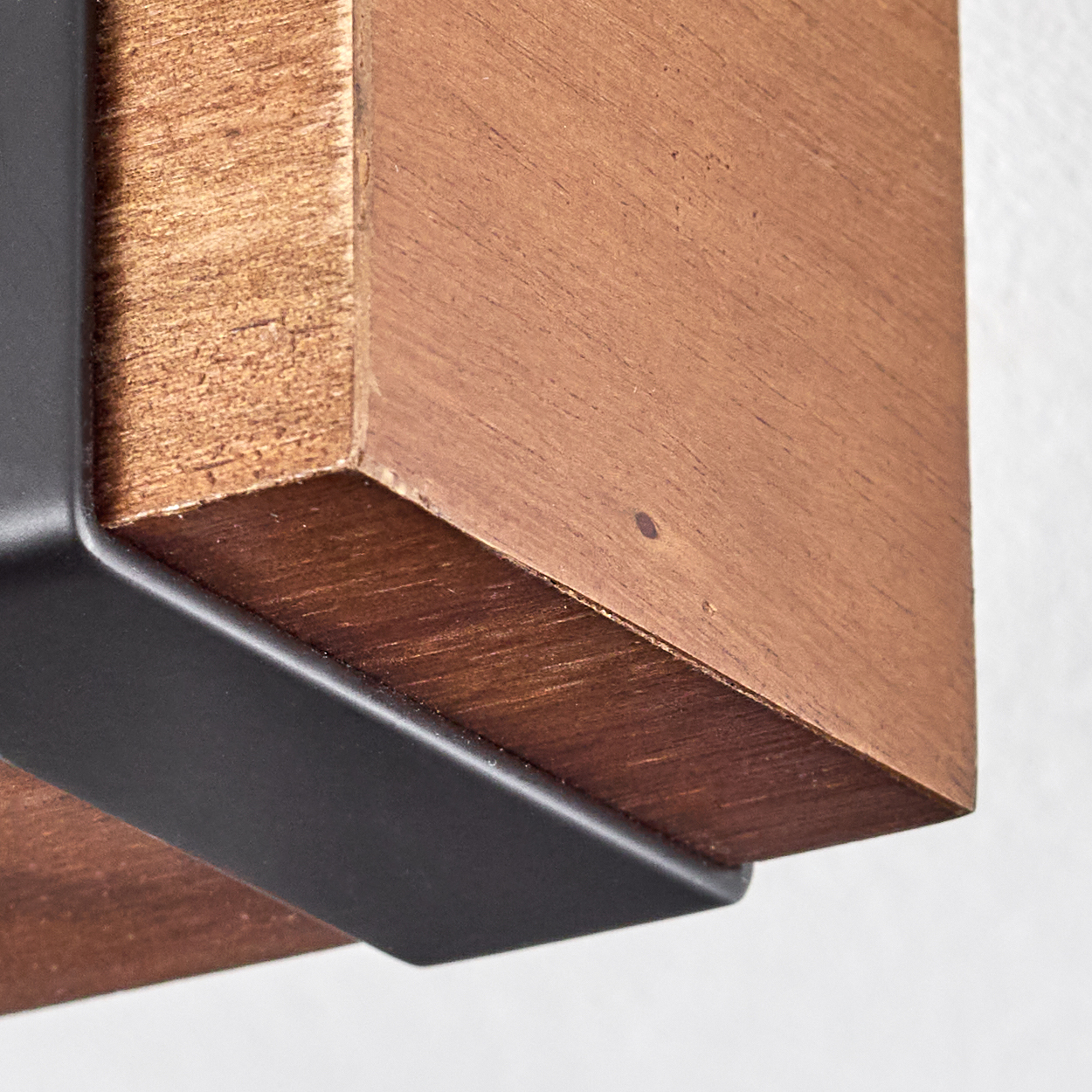 Nahaufnahme eines Holzregals mit einer schwarzen Metallhalterung. Das Holz ist braun, der Hintergrund ist weiß.