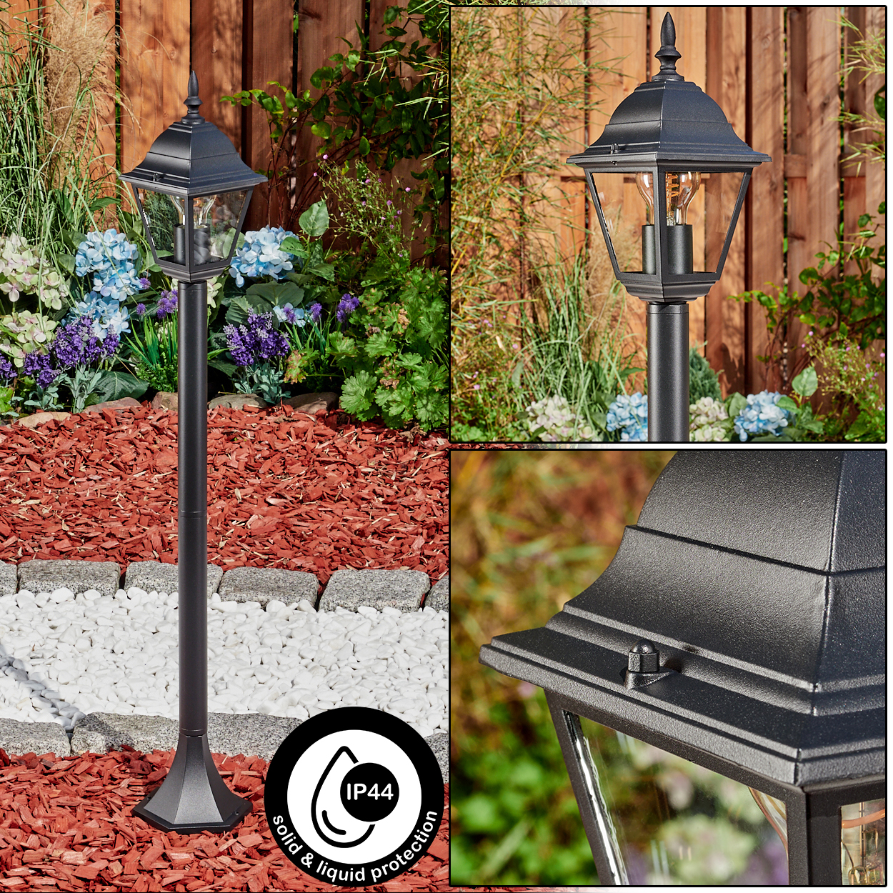 Schwarze Außenlaterne in einem Garten mit Blumen und Mulch. Die Lampe ist schwarz und hat ein Glasgehäuse. Der Hintergrund ist ein Holzzaun.