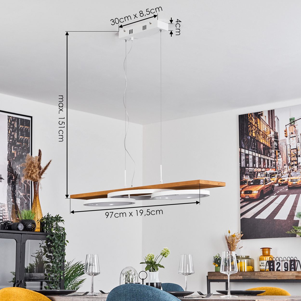 Eine moderne Pendelleuchte mit Holz- und weißen Elementen hängt über einem Esstisch mit Gläsern und Stühlen. Ein Stadtbild-Kunstwerk.