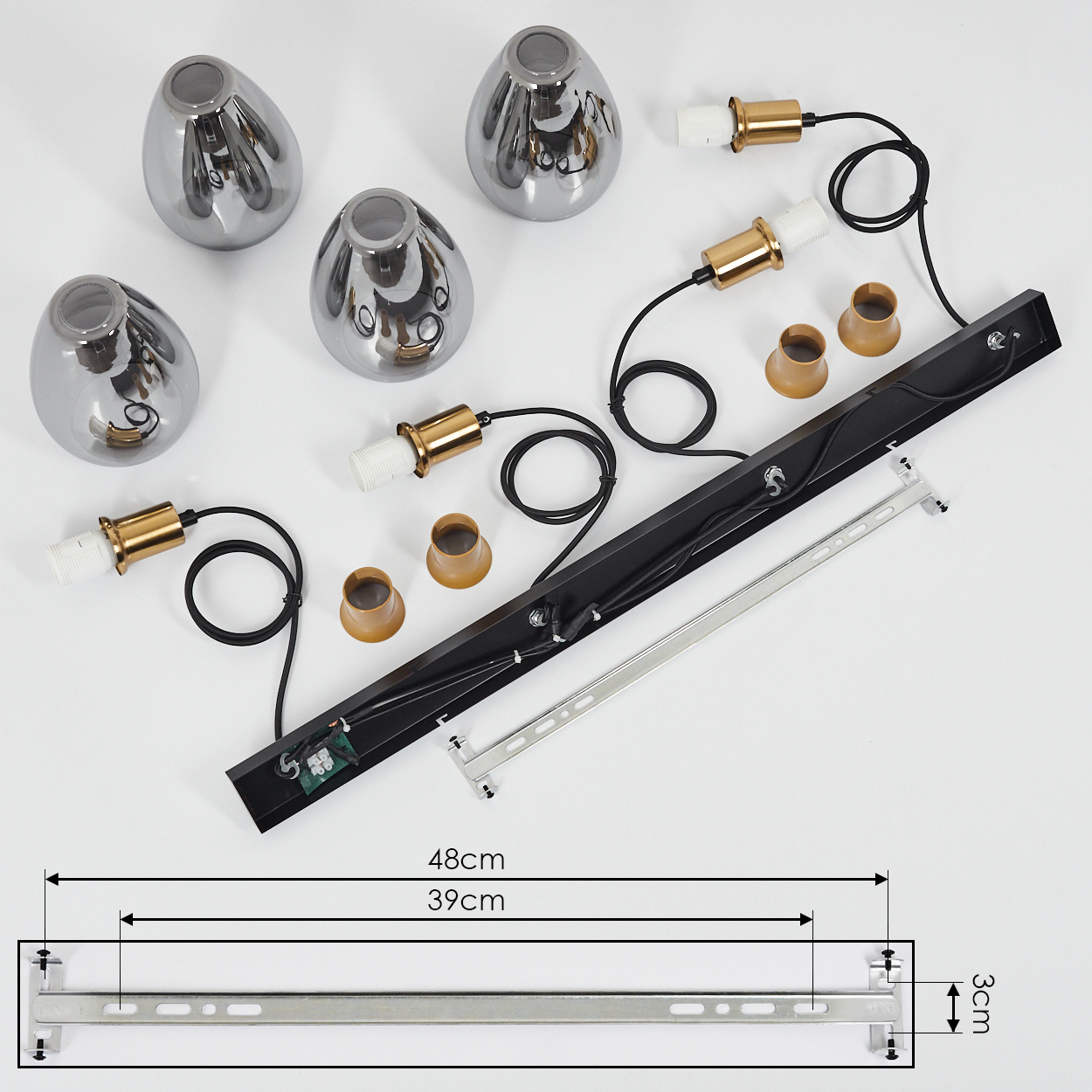 Draufsicht einer zerlegten modernen Lampe. Enthält Chromschirme, Messing-Glühbirnenhalter, schwarze Kabel und eine schwarze rechteckige Basis mit silberner Halterung.