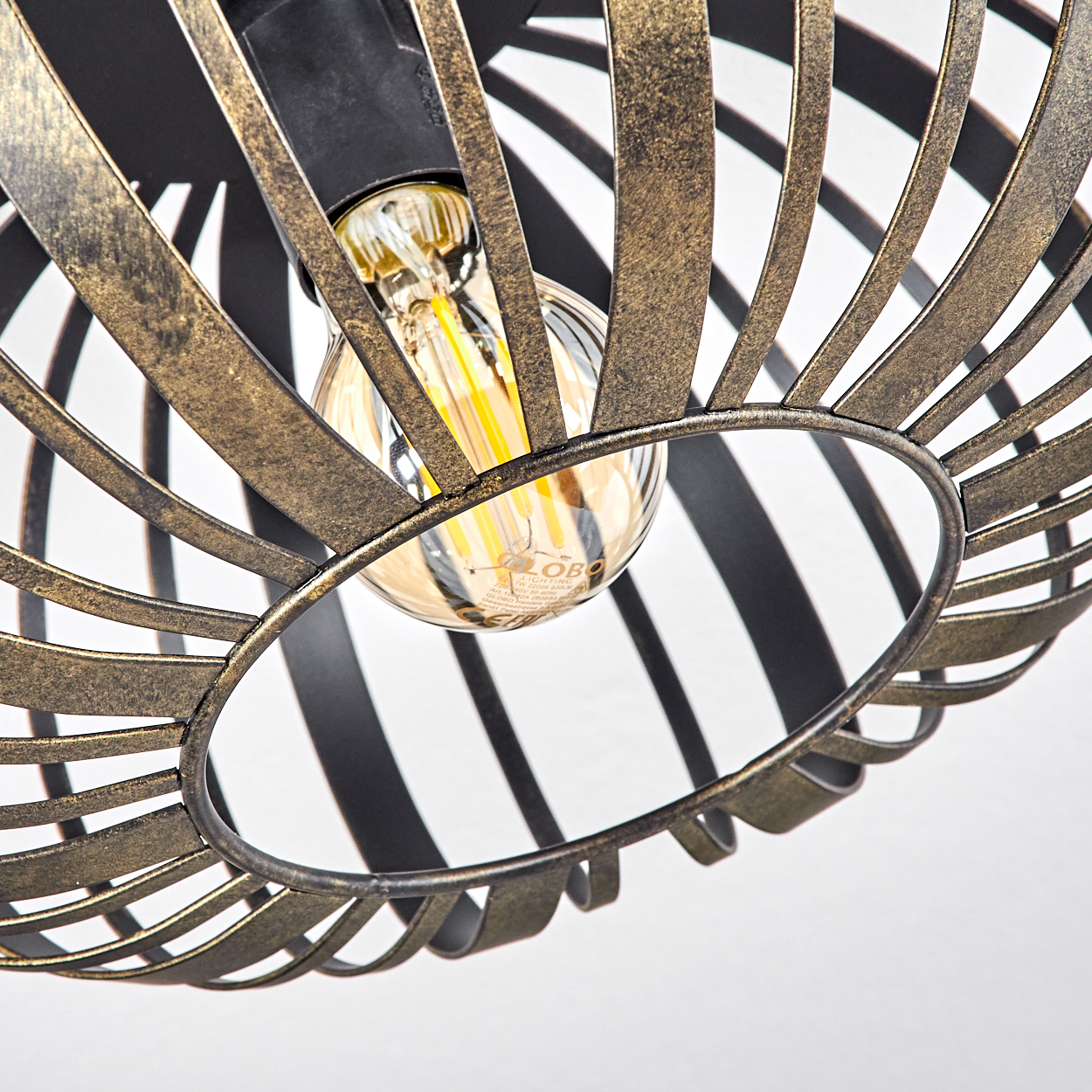 Nahaufnahme einer dekorativen Leuchte mit käfigartigem Design. Eine Glühbirne ist von einem Metallrahmen umgeben, vor weißem Hintergrund.