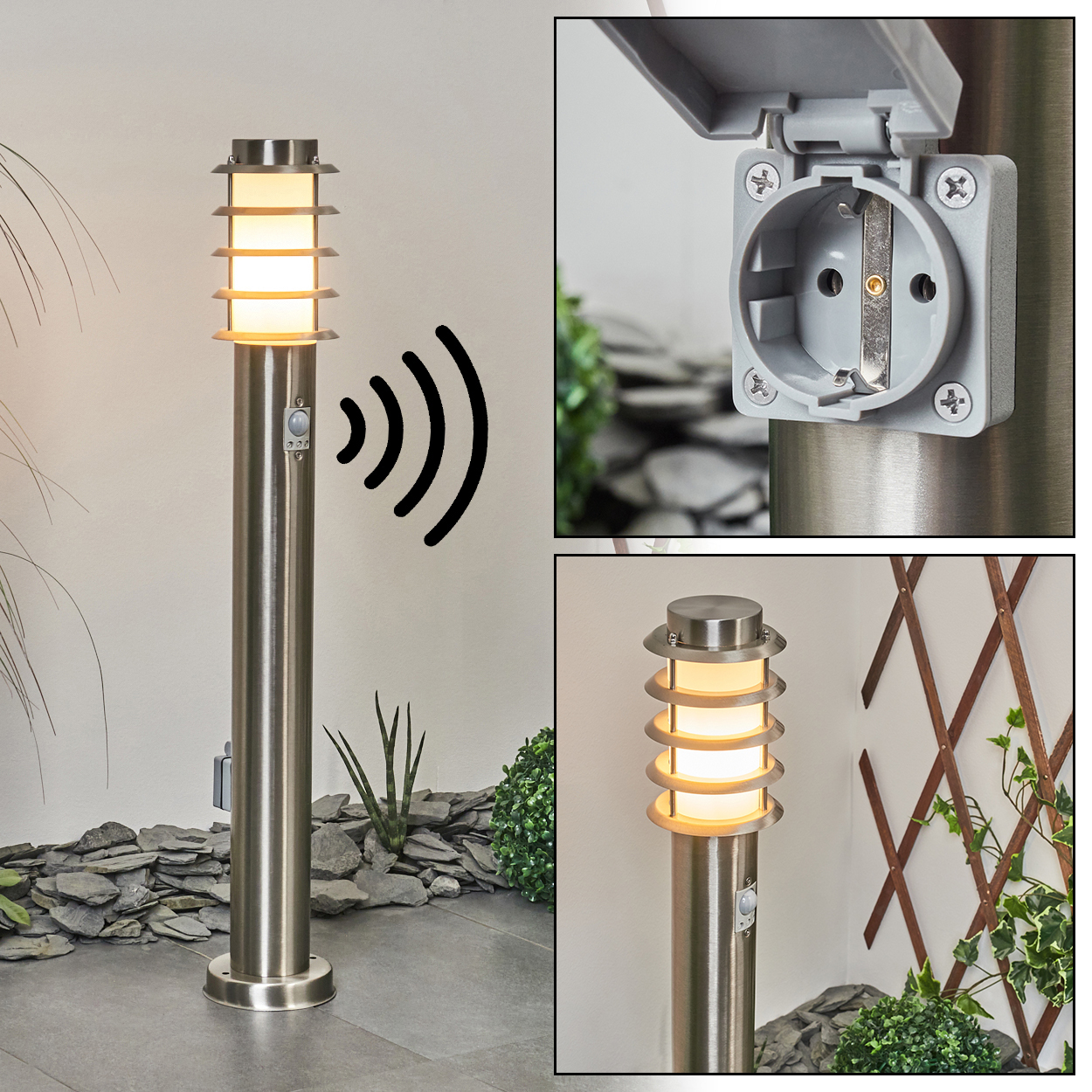 Eine silberne Außenlampe mit Sensor, Steckdose und Licht. Im Hintergrund eine Wand, Pflanzen und ein Holzgitter.