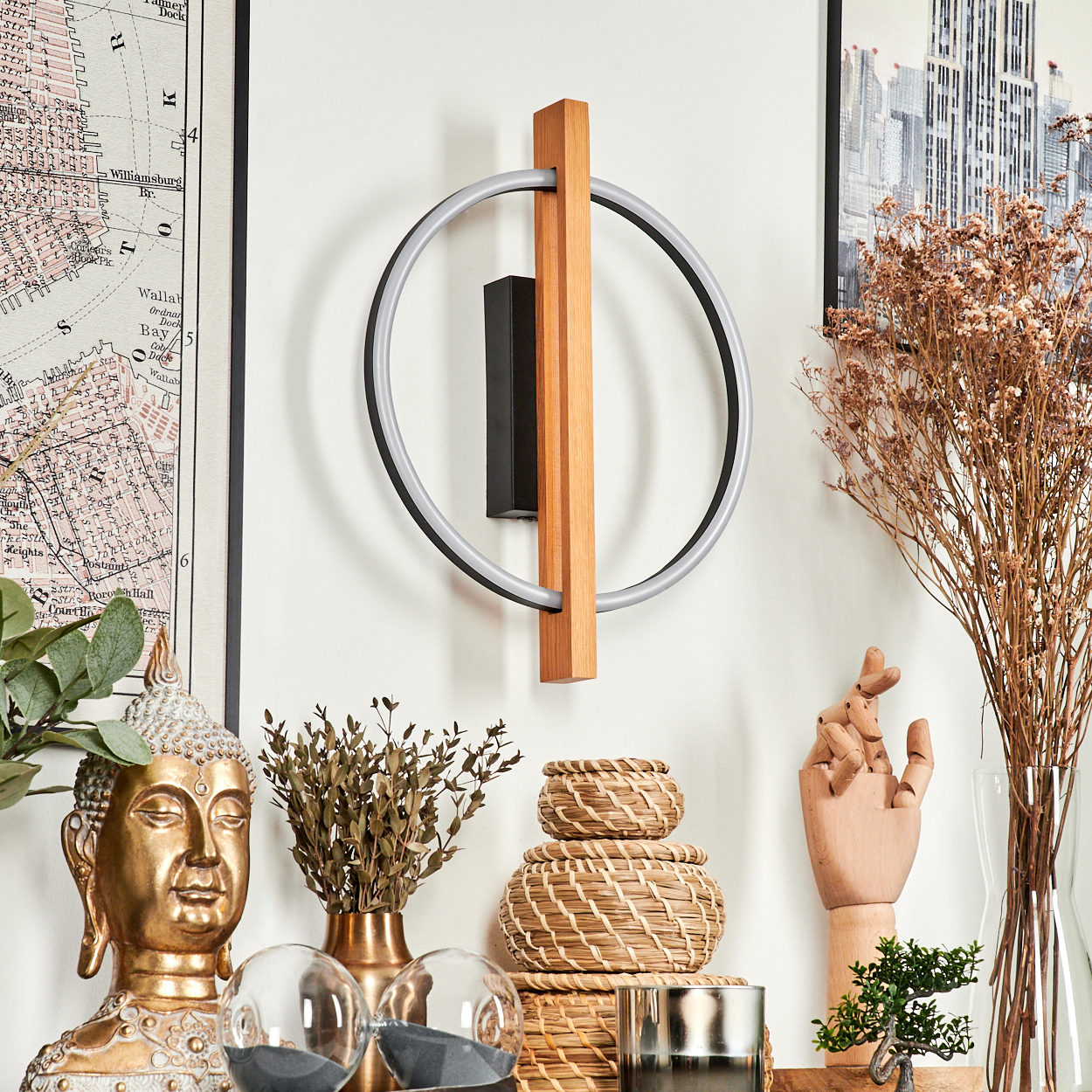 Eine Wandleuchte mit Holzakzent. Dekorative Elemente wie eine Buddha-Statue, Trockenblumen und Körbe im Vordergrund.