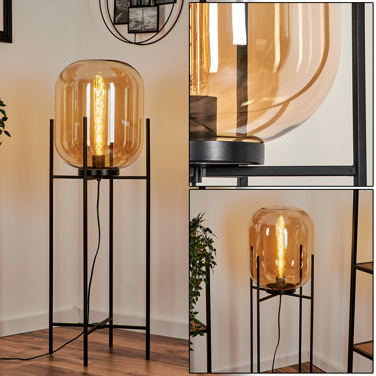 Eine moderne Stehlampe mit großem bernsteinfarbenem Glasschirm und sichtbarer Glühbirne. Sie steht auf einem schwarzen Metallrahmen. Der Hintergrund ist eine weiße Wand.