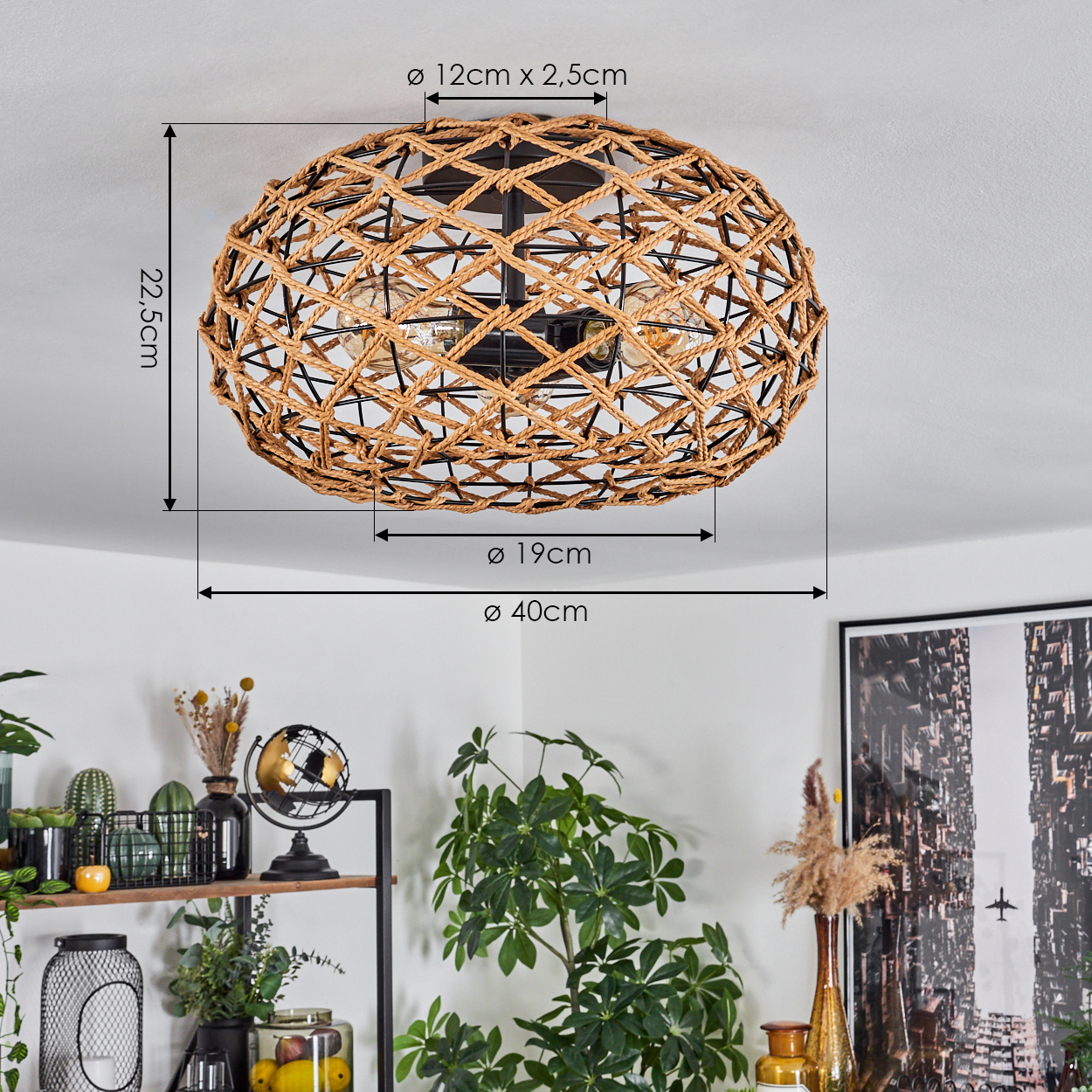 Eine gewebte Leuchte hängt von der Decke. Darunter ein Regal mit Pflanzen und Dekoration. Rechts ein großer Kunstdruck.