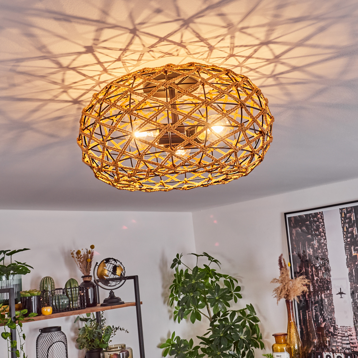 Eine gewebte, kugelförmige Lampe hängt von der Decke und wirft gemusterte Schatten. Pflanzen, Regale mit Dekor und ein Stadtposter sind unten sichtbar.