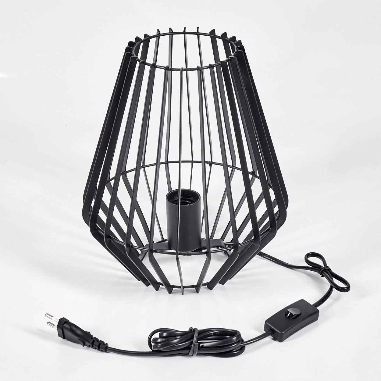Schwarze Metallkäfiglampe auf weißem Hintergrund. Sie hat ein Netzkabel mit Schalter und Stecker.