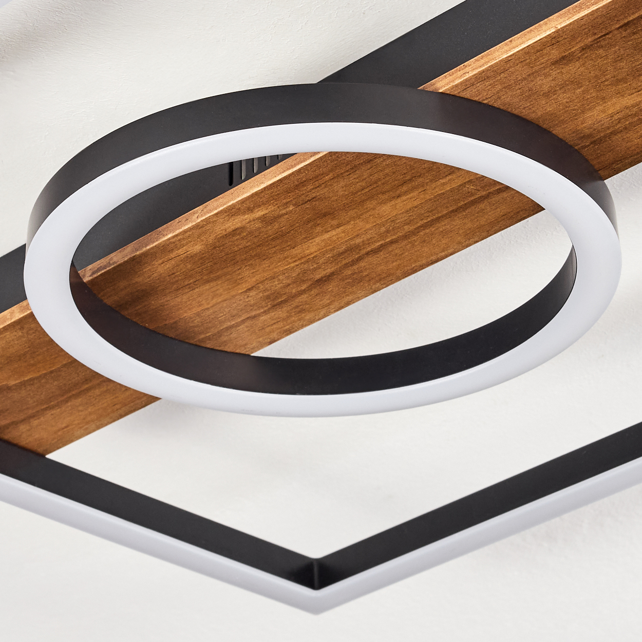 Eine moderne Deckenleuchte mit Holzbalken und einer schwarzen kreisförmigen Leuchte mit weißem Innenlicht.