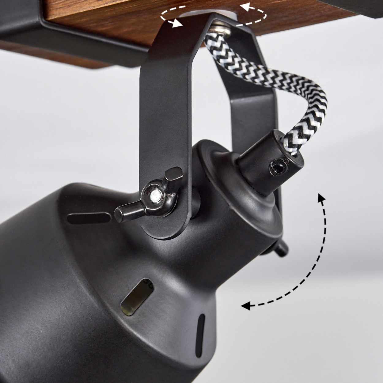 Schwarze Lampe mit Holzplatte. Ein schwarz-weißes Kabel verbindet die Lampe. Die Lampe hat einen Drehmechanismus.