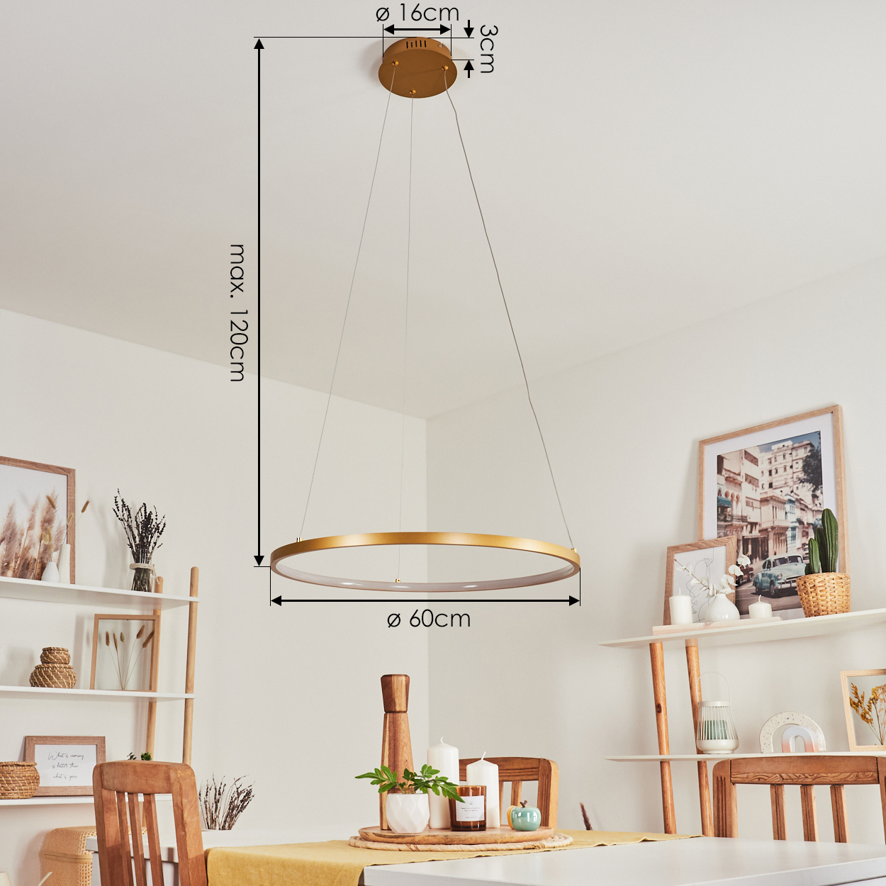 Eine goldene Ringlampe hängt von der Decke über einem Tisch mit Kerzen und Dekorationen. Der Raum hat eine weiße Wand und Holzmöbel.