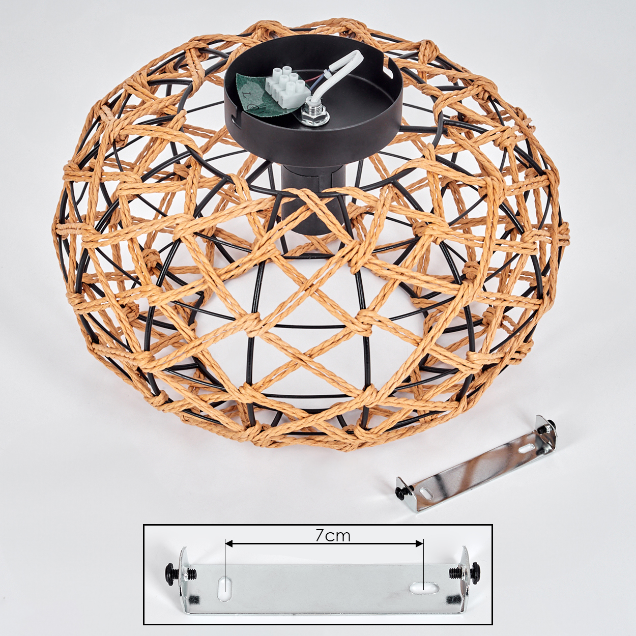 Ein gewebter Lampenschirm mit schwarzem Metallrahmen. Eine Metallhalterung mit Schrauben befindet sich in der Nähe. Der Lampenschirm hat ein Maß von 7 cm.