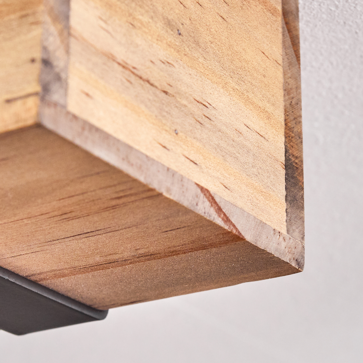 Nahaufnahme einer hölzernen Regalecke. Das Regal besteht aus hellbraunem Holz mit dunkler Metallstütze.