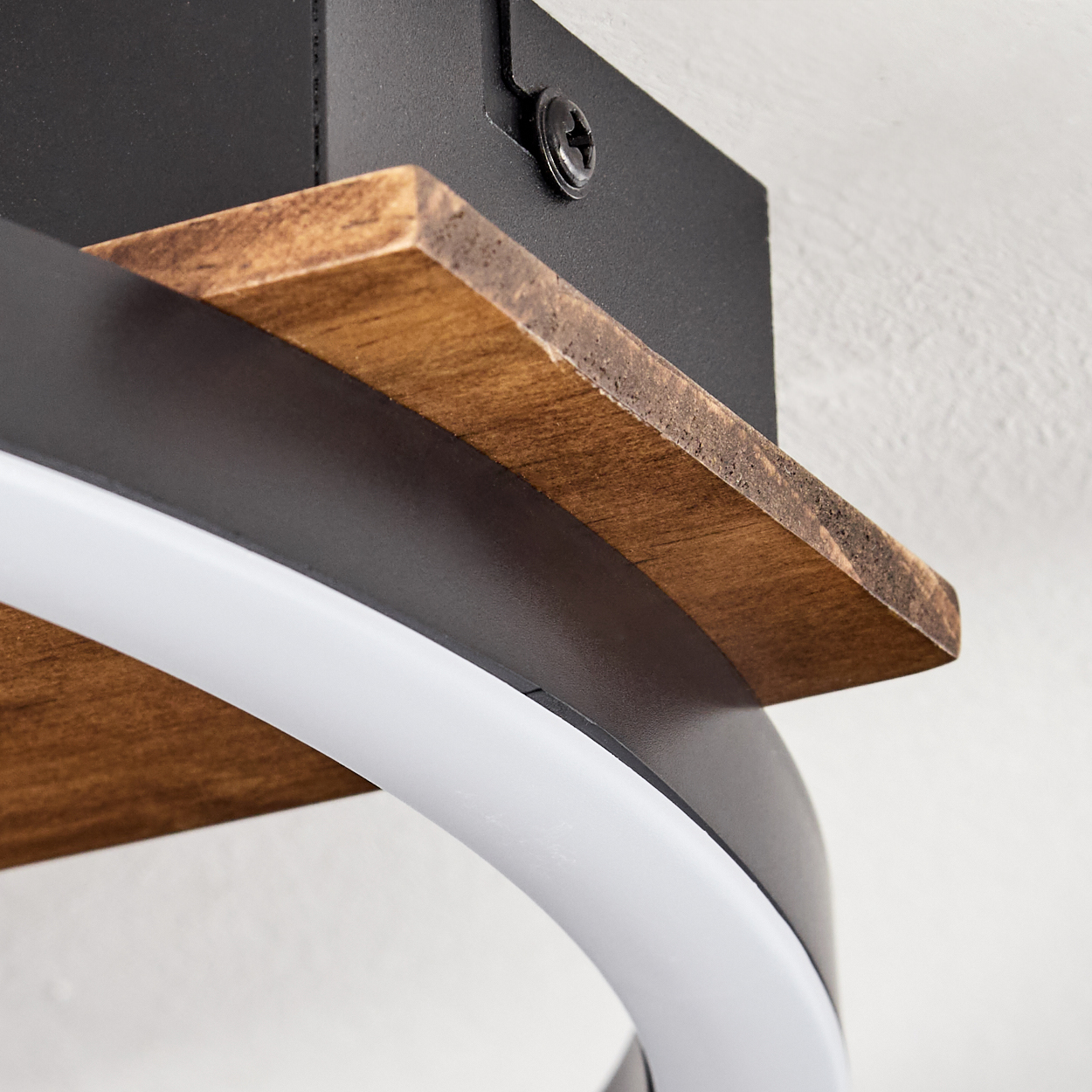 Nahaufnahme einer modernen Leuchte. Sie hat ein Holzregal, einen schwarzen Metallrahmen und ein gebogenes weißes LED-Licht. Der Hintergrund ist weiß.