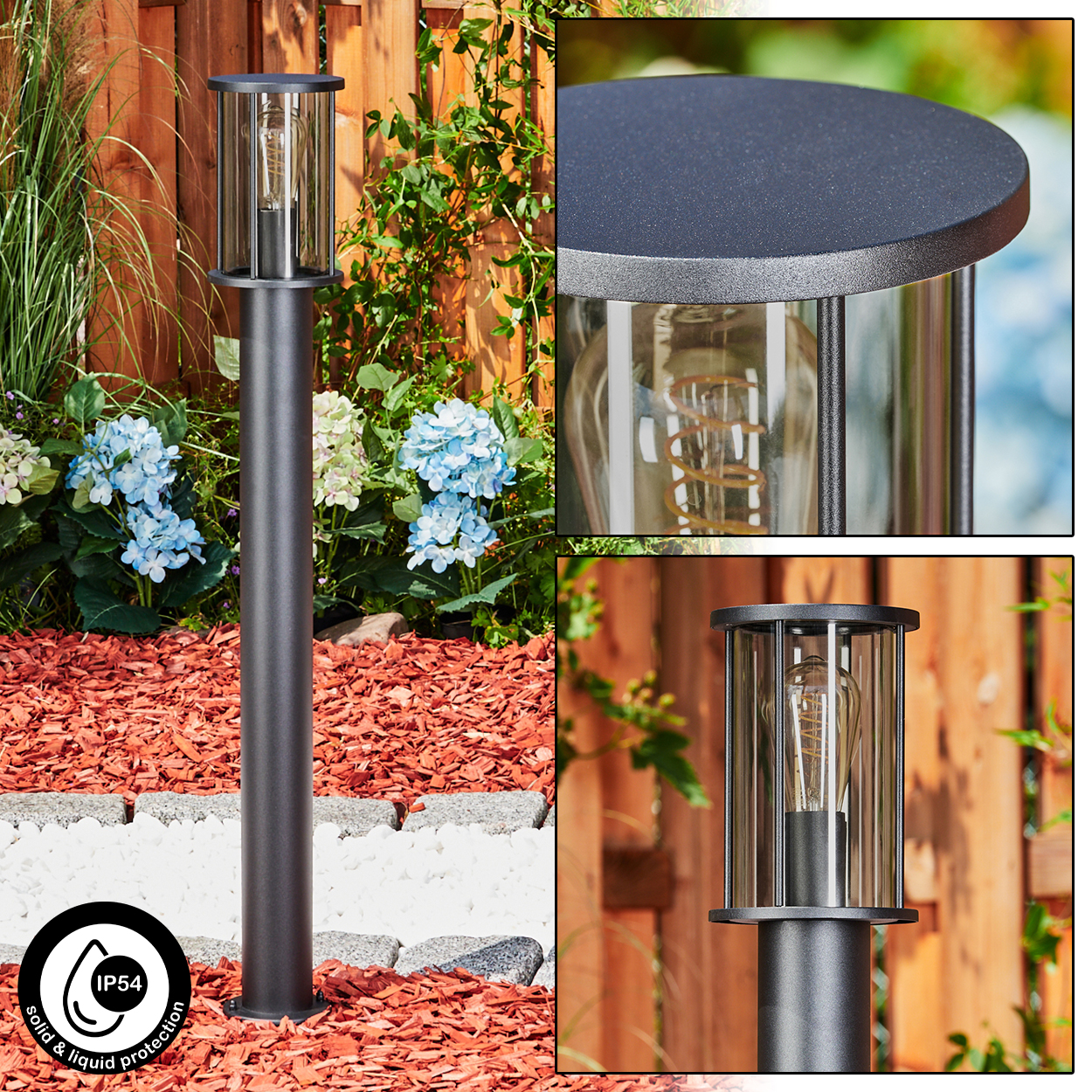Eine dunkelgraue Außenlampe mit Glaseinfassung. Sie hat eine Glühbirne im Inneren. Der Hintergrund zeigt einen Garten mit Blumen und einem Holzzaun.