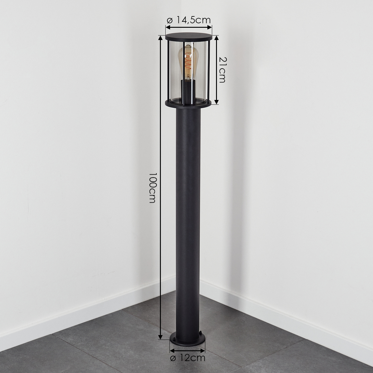 Schwarze Außenlampe mit Maßen. Sie hat eine zylindrische Form, eine Glasabdeckung und eine Glühbirne.