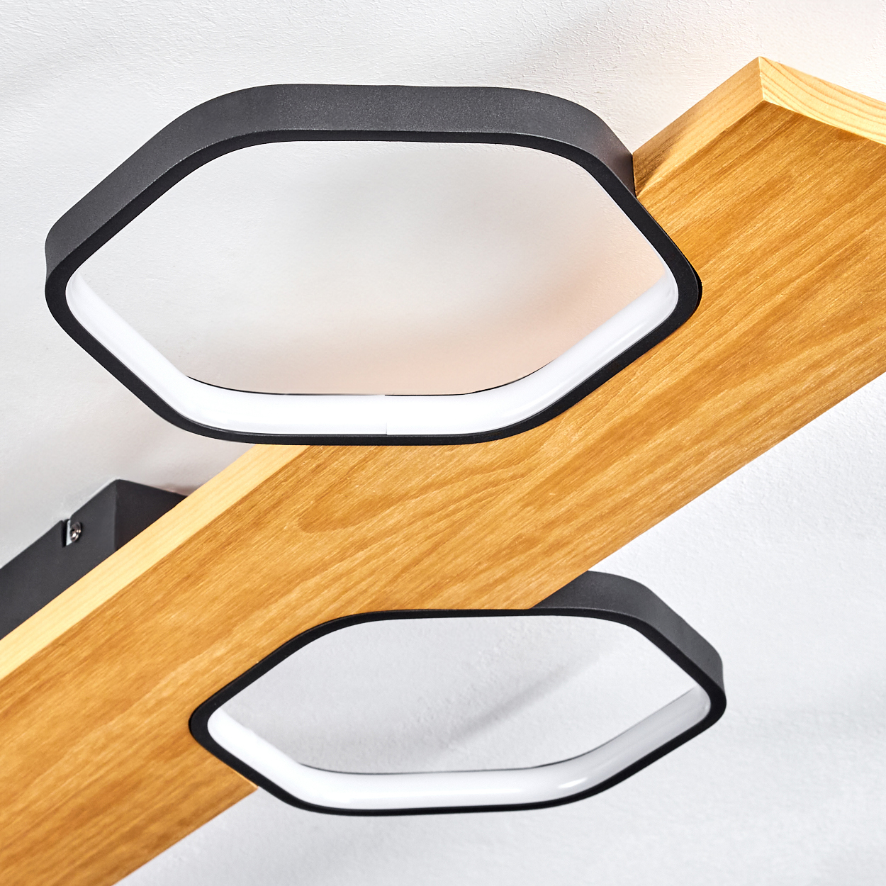 Zwei moderne Deckenleuchten mit schwarzen Rahmen und weißen Innenlichtern, montiert auf einem Holzbalken. Weißer Hintergrund.