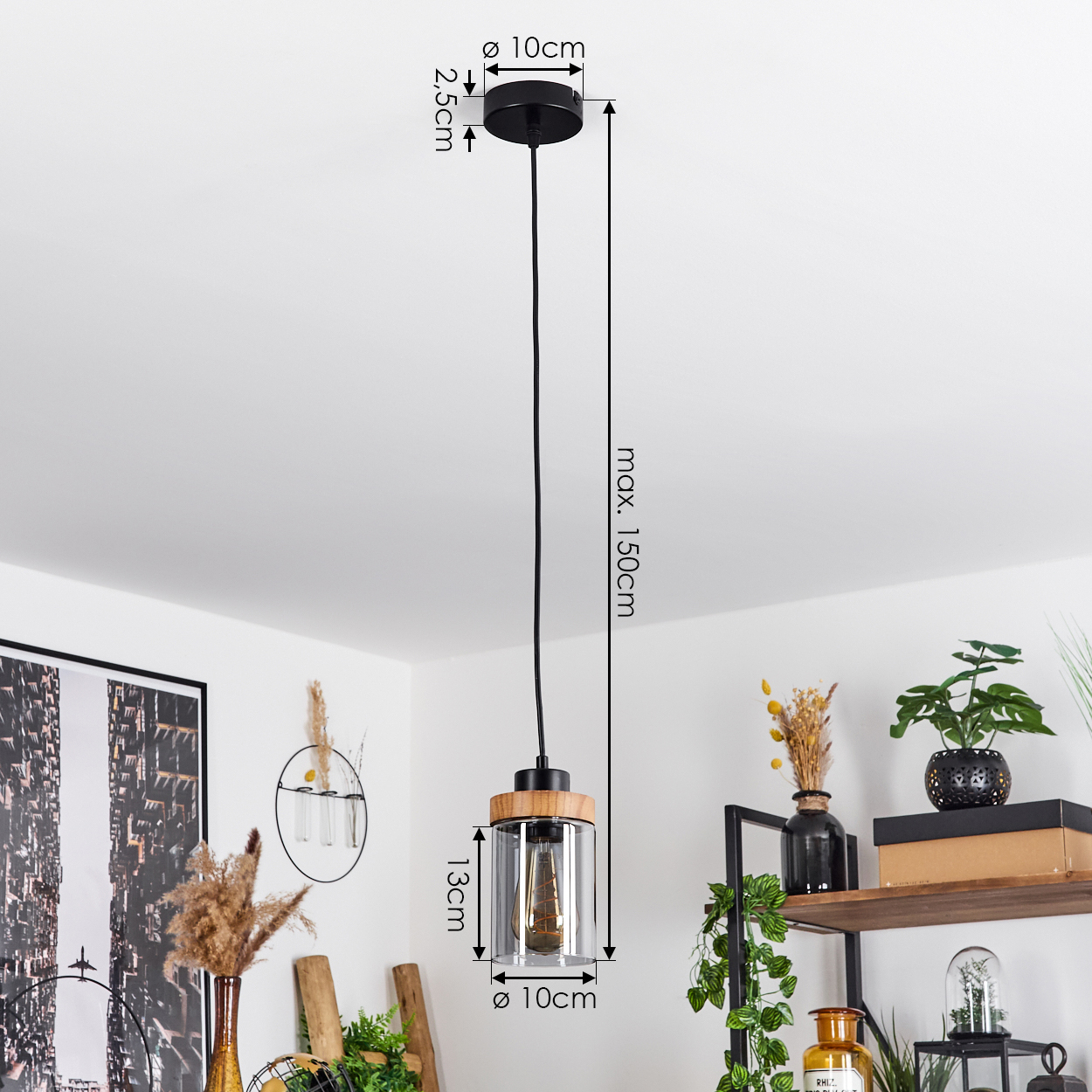 Eine Pendelleuchte mit schwarzem Aufsatz und Holz-Glas-Boden. Die Lampe hängt in einem Raum mit Regalen und Pflanzen.
