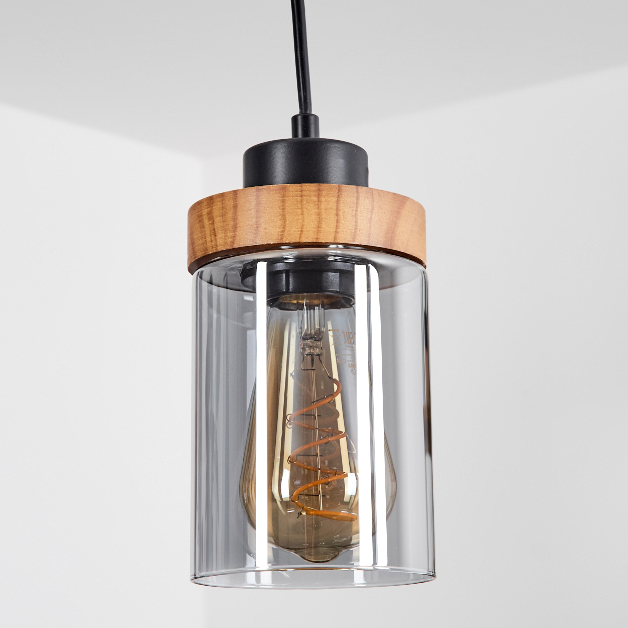 Eine Pendelleuchte mit Holz- und Glasschirm. Die Glühbirne ist im Glaskörper sichtbar. Der Hintergrund ist weiß.