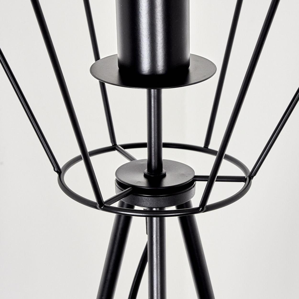 Nahaufnahme eines schwarzen Metallkerzenhalters mit geometrischem Käfigdesign. Der Hintergrund ist schlicht weiß.