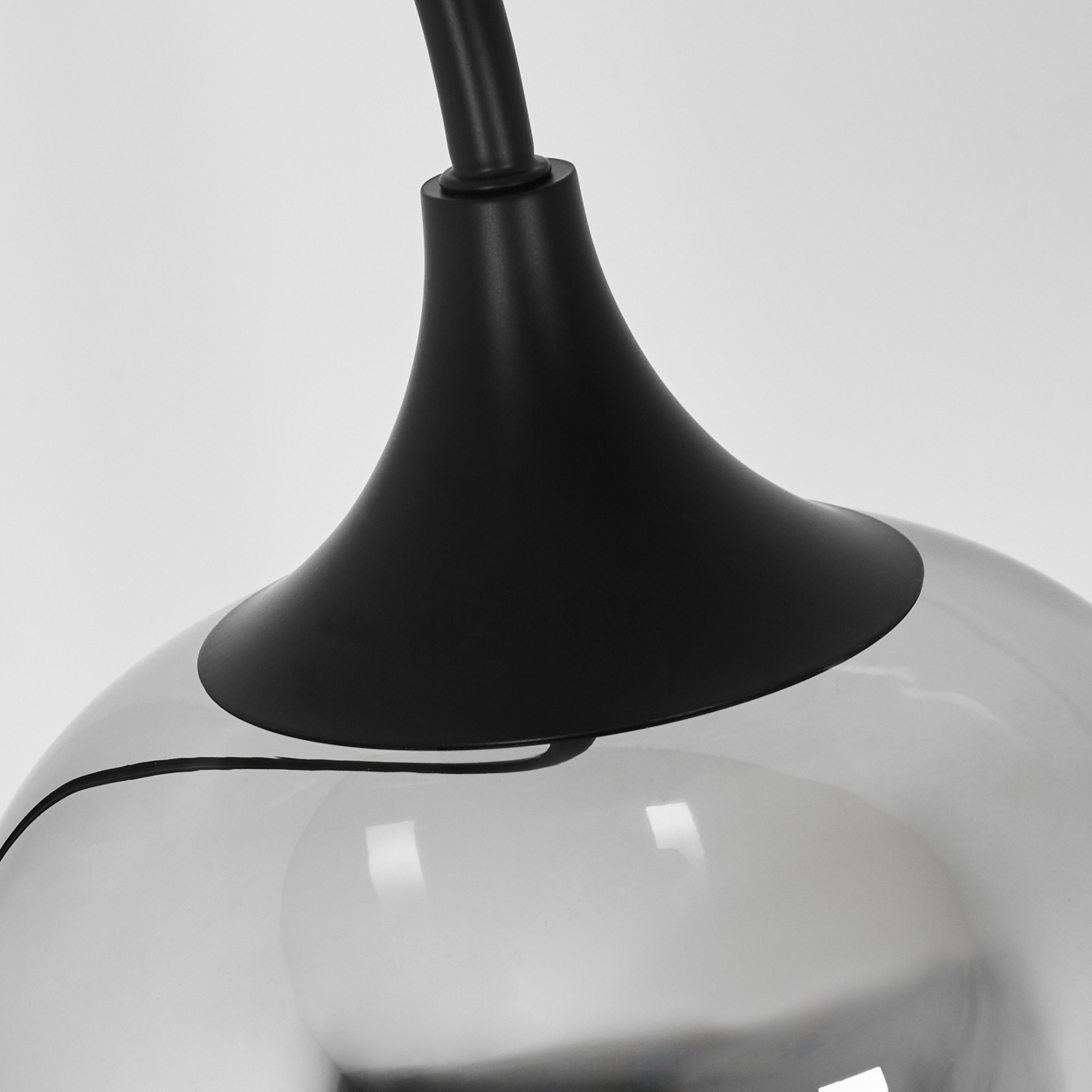 Nahaufnahme einer modernen Lampe. Schwarzer Stiel und Oberteil, reflektierender silbergrauer Boden. Sauberer weißer Hintergrund.