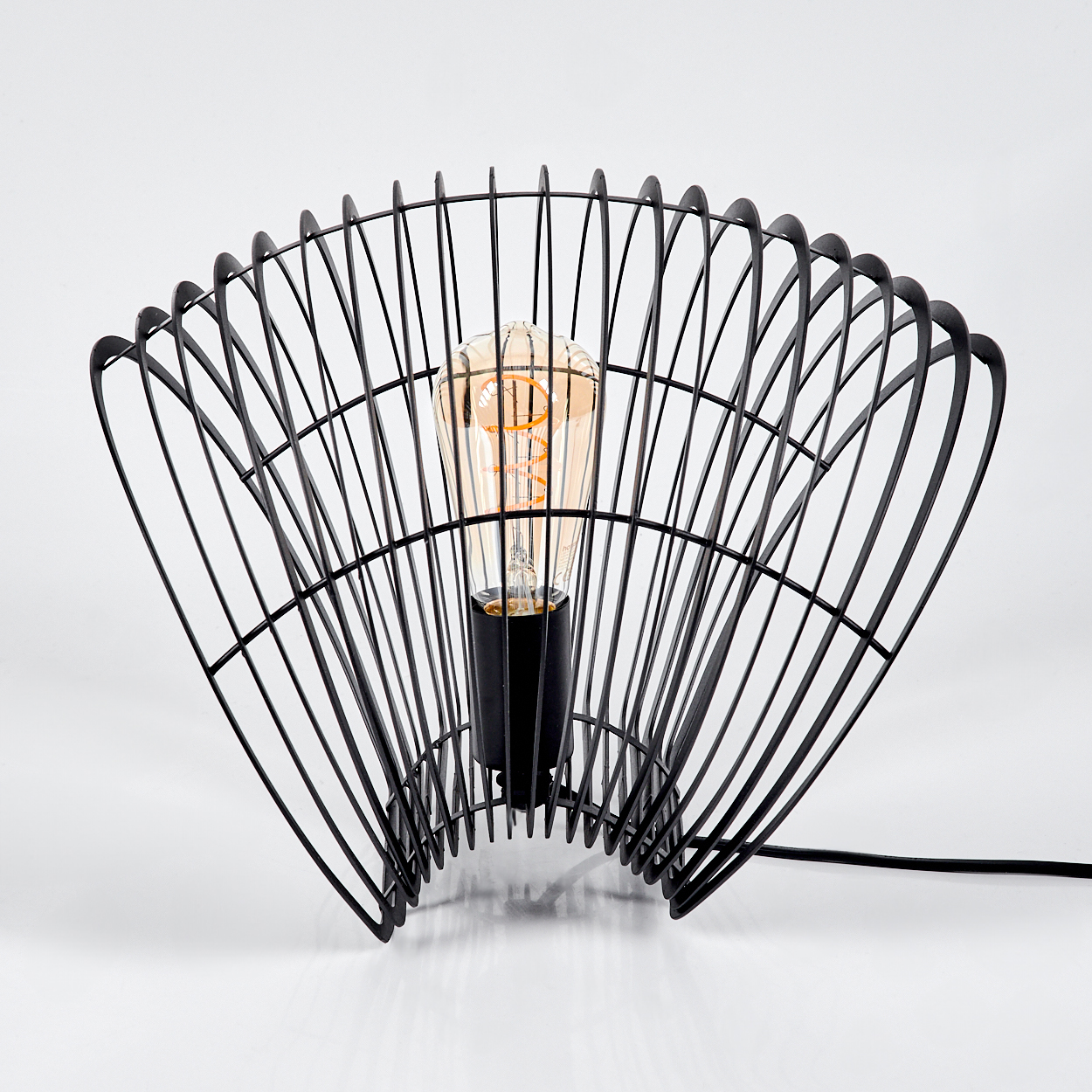 Eine schwarze Drahtlampe mit sichtbarer Glühbirne. Die Lampe hat ein fächerartiges Design und der Hintergrund ist weiß.