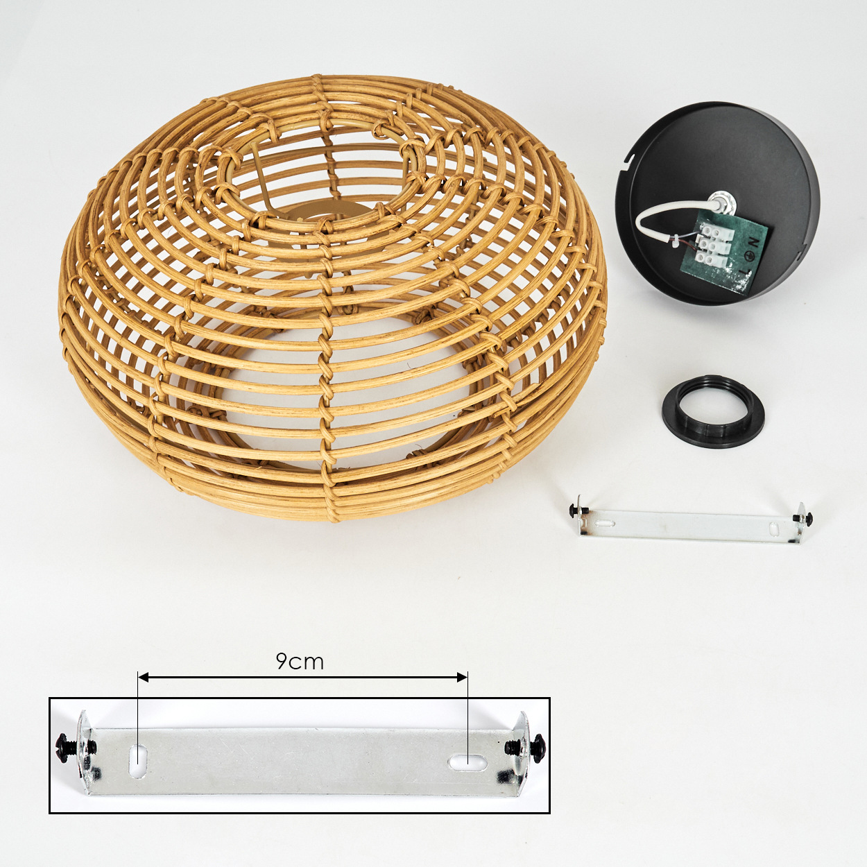 Eine zerlegte Lampe. Zu den Komponenten gehören ein gewebter Lampenschirm, eine schwarze elektrische Vorrichtung, eine Metallhalterung und ein schwarzer Ring.