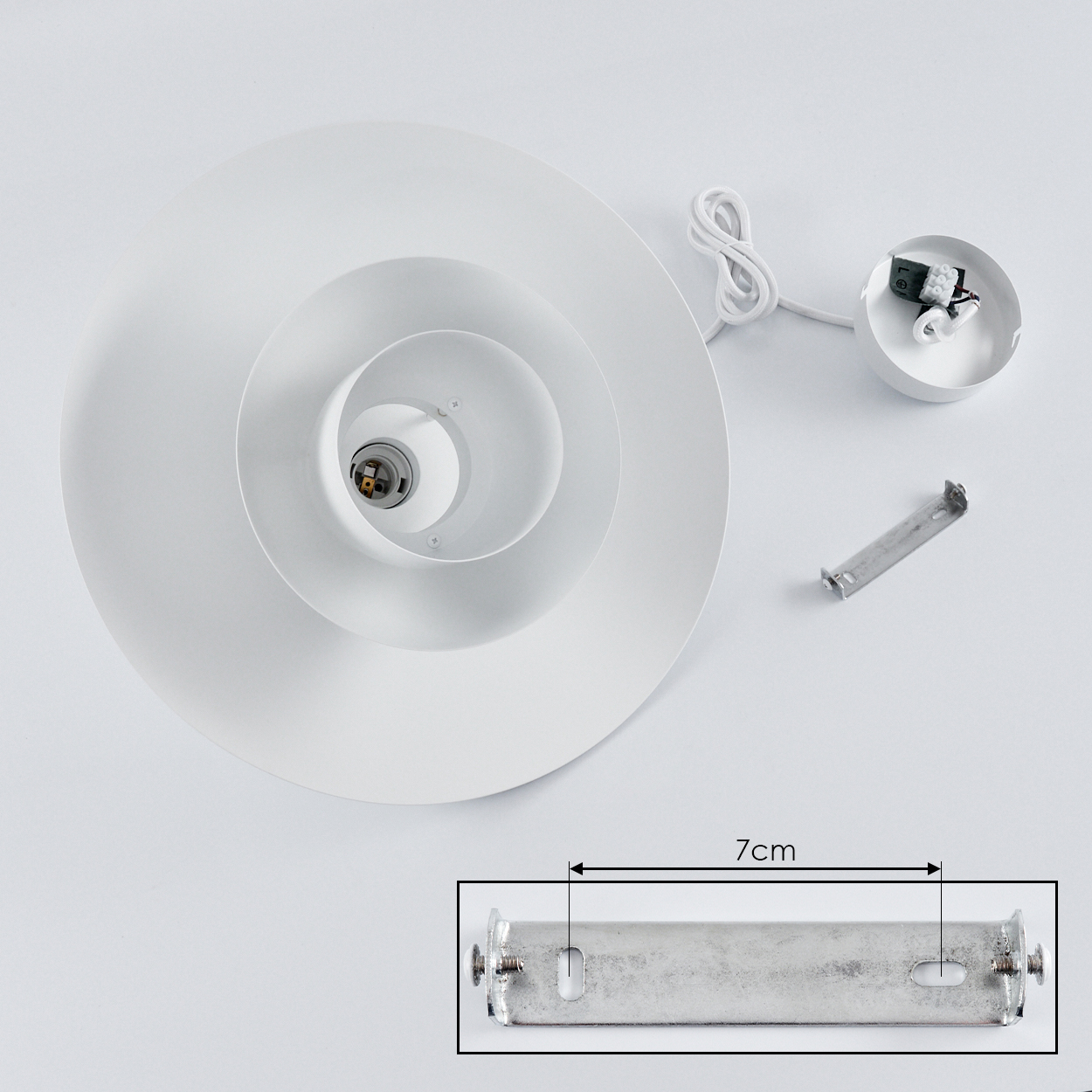 Zerlegte weiße Deckenlampe mit Schirm, Verdrahtung und Montagezubehör. Eine 7 cm lange Halterung wird hervorgehoben.