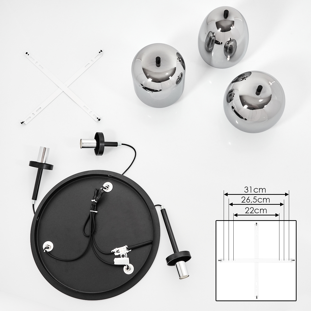 Komponenten einer modernen Lampe, darunter drei reflektierende Kugeln, ein schwarzer Sockel und Montagezubehör, auf weißem Untergrund angeordnet.