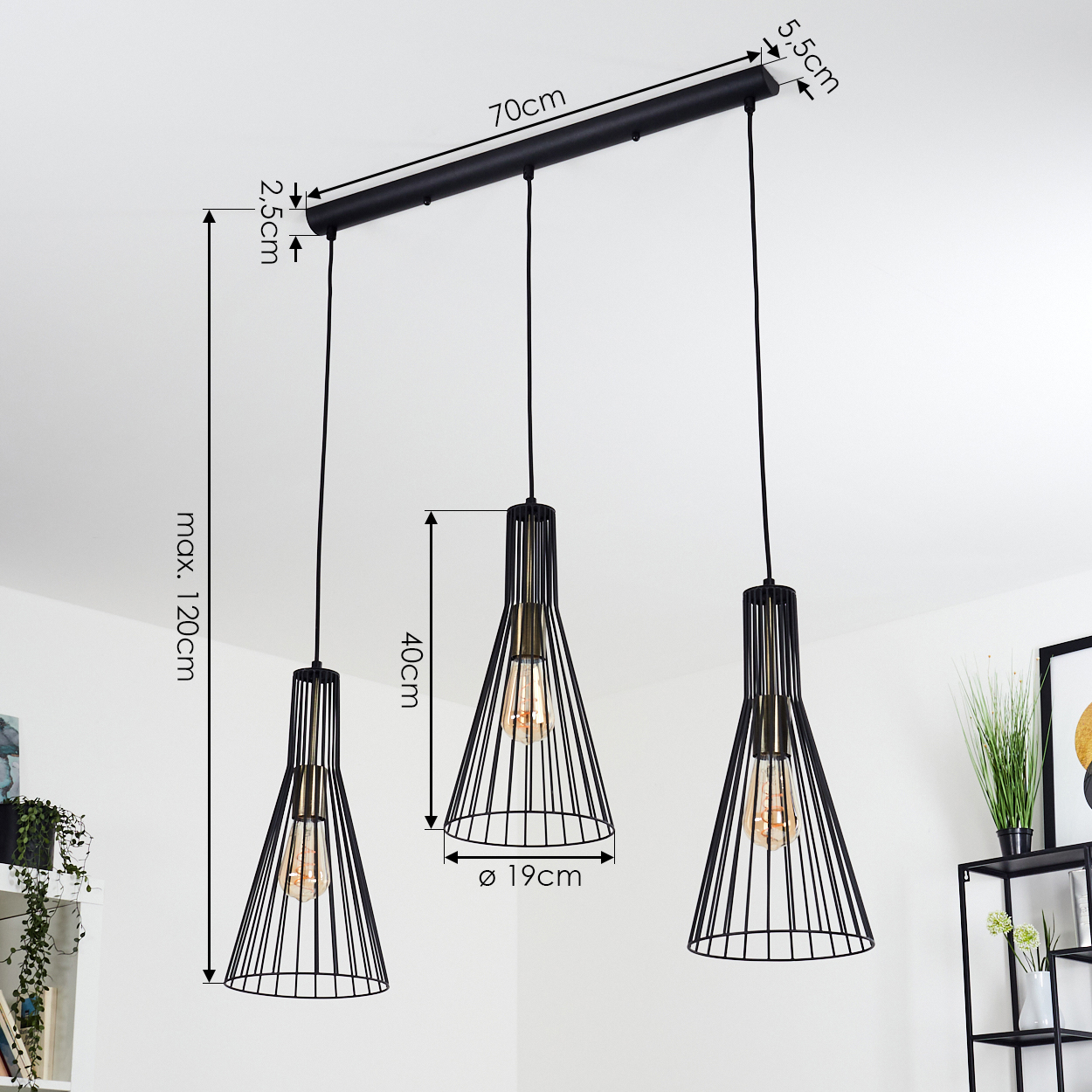 Drei schwarze Drahtgestell-Pendelleuchten hängen von der Decke. Abmessungen sind angegeben. Pflanzen und ein Regal sind im Hintergrund.