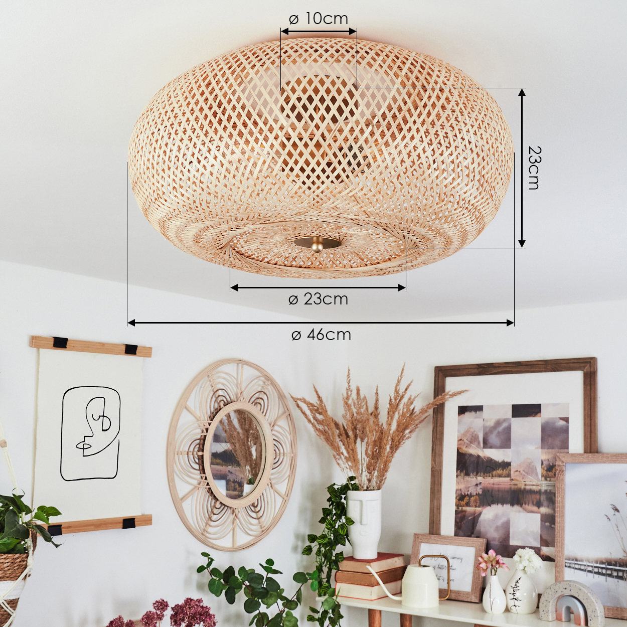 Eine gewebte Rattanlampe hängt. Darunter zeigt eine weiße Wand Kunst, einen Spiegel und ein Regal mit Dekoration und Pflanzen.