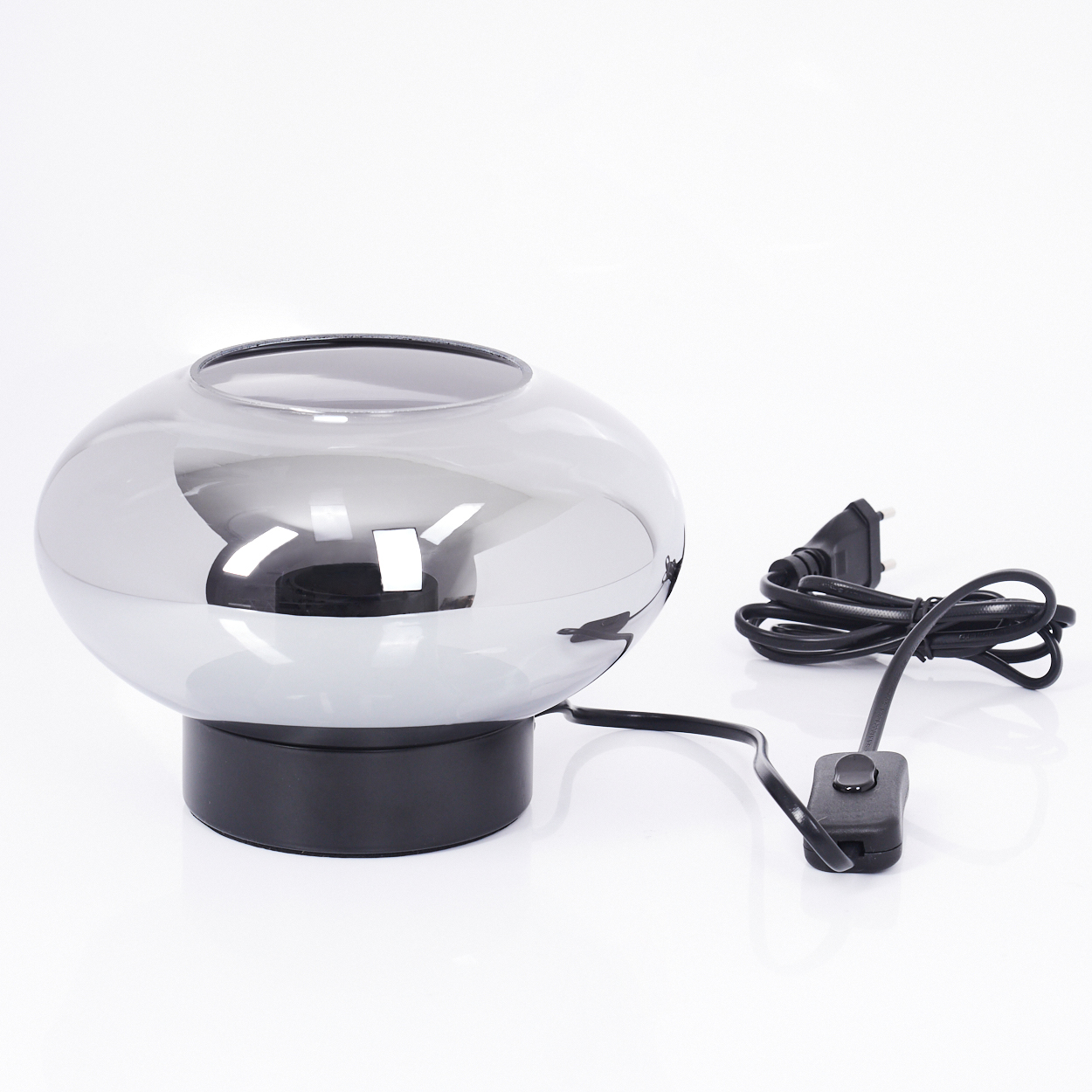 Eine reflektierende graue Lampe steht auf einem schwarzen Sockel, mit schwarzem Kabel und Stecker. Der Hintergrund ist weiß.