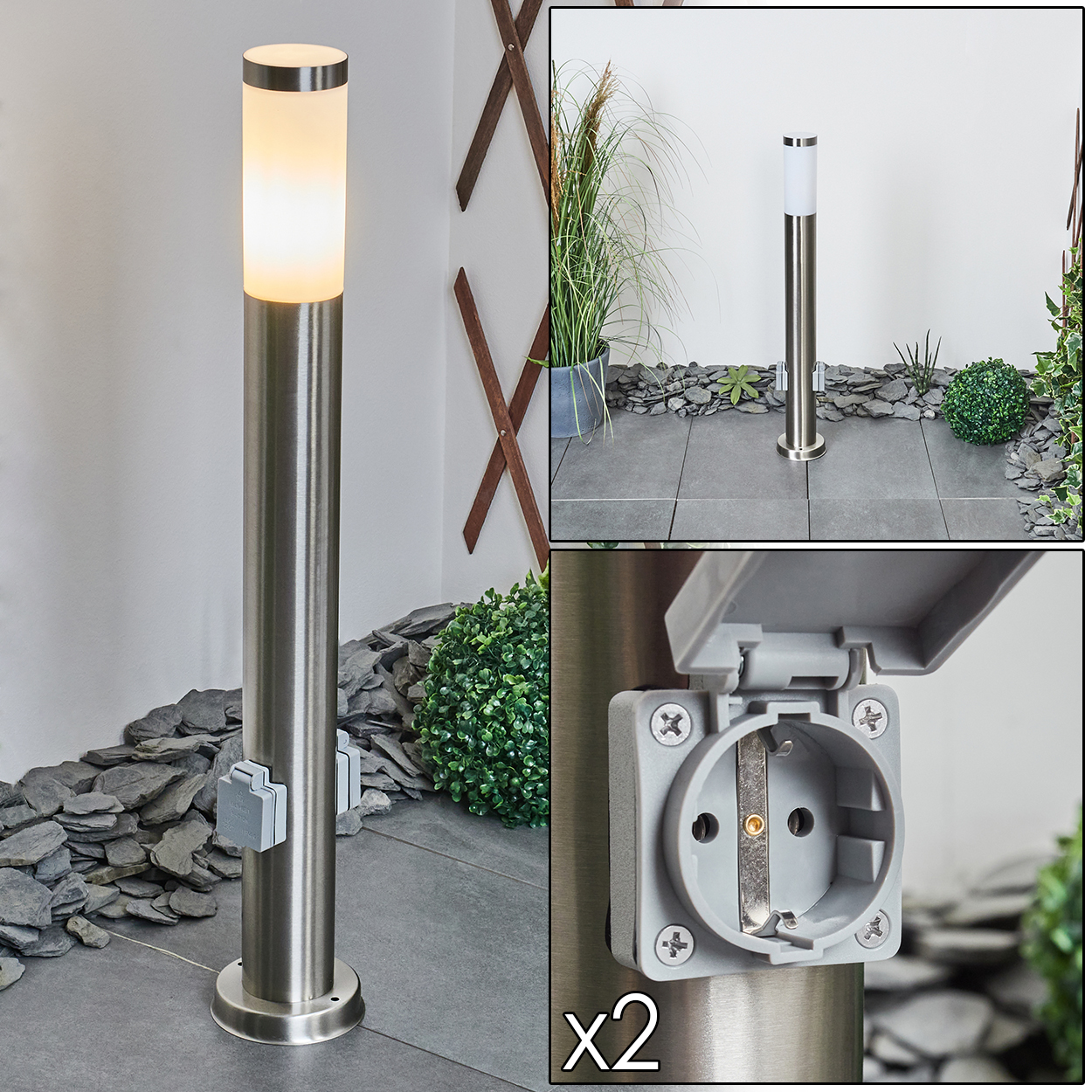 Eine Edelstahl-Außenlampe mit integrierter Steckdose. Im Hintergrund ein Garten mit Pflanzen und Pflastersteinen.