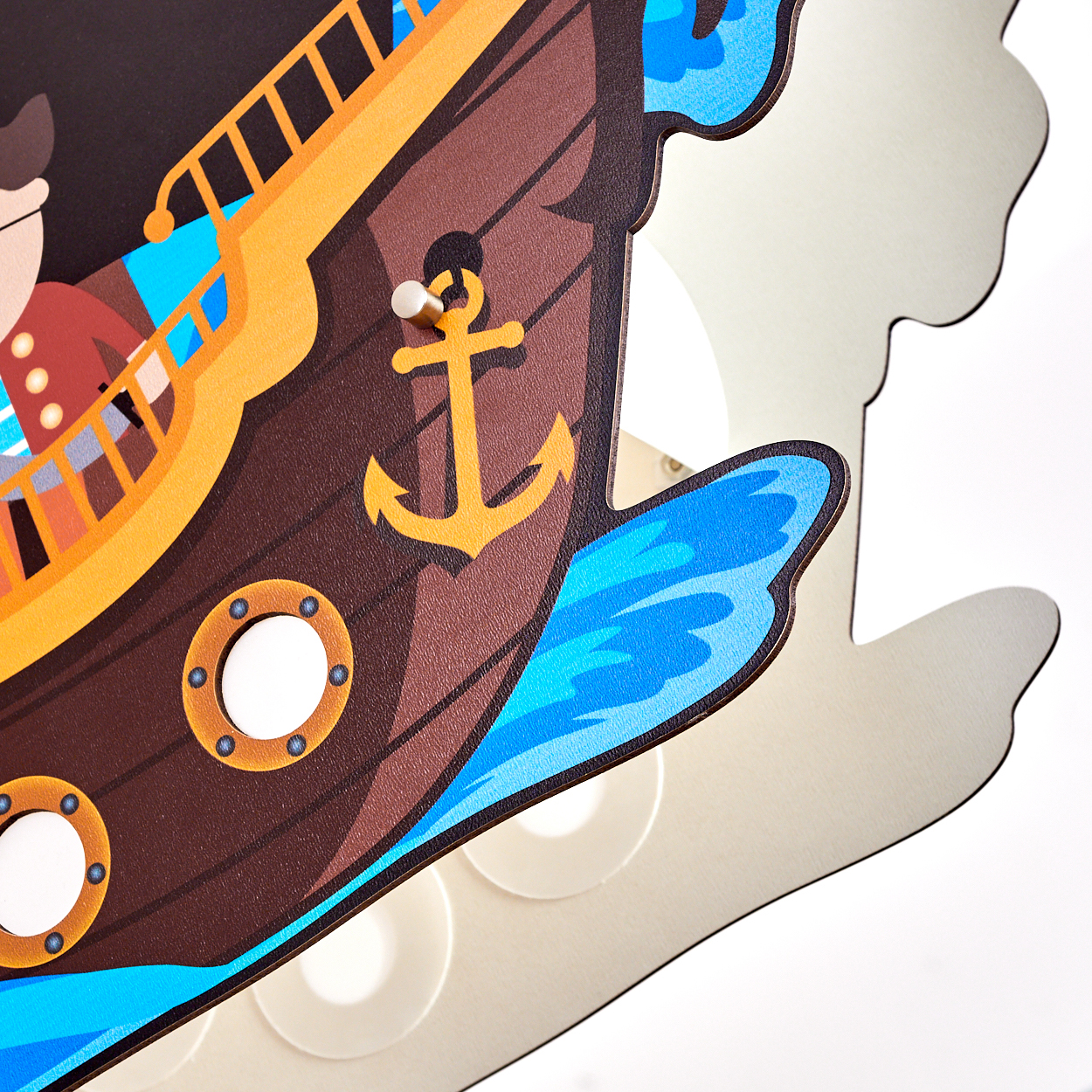 Eine bunte Piratenschiff-Illustration mit goldenem Anker, blauen Wellen und Bullaugen. Der Hintergrund ist weiß.
