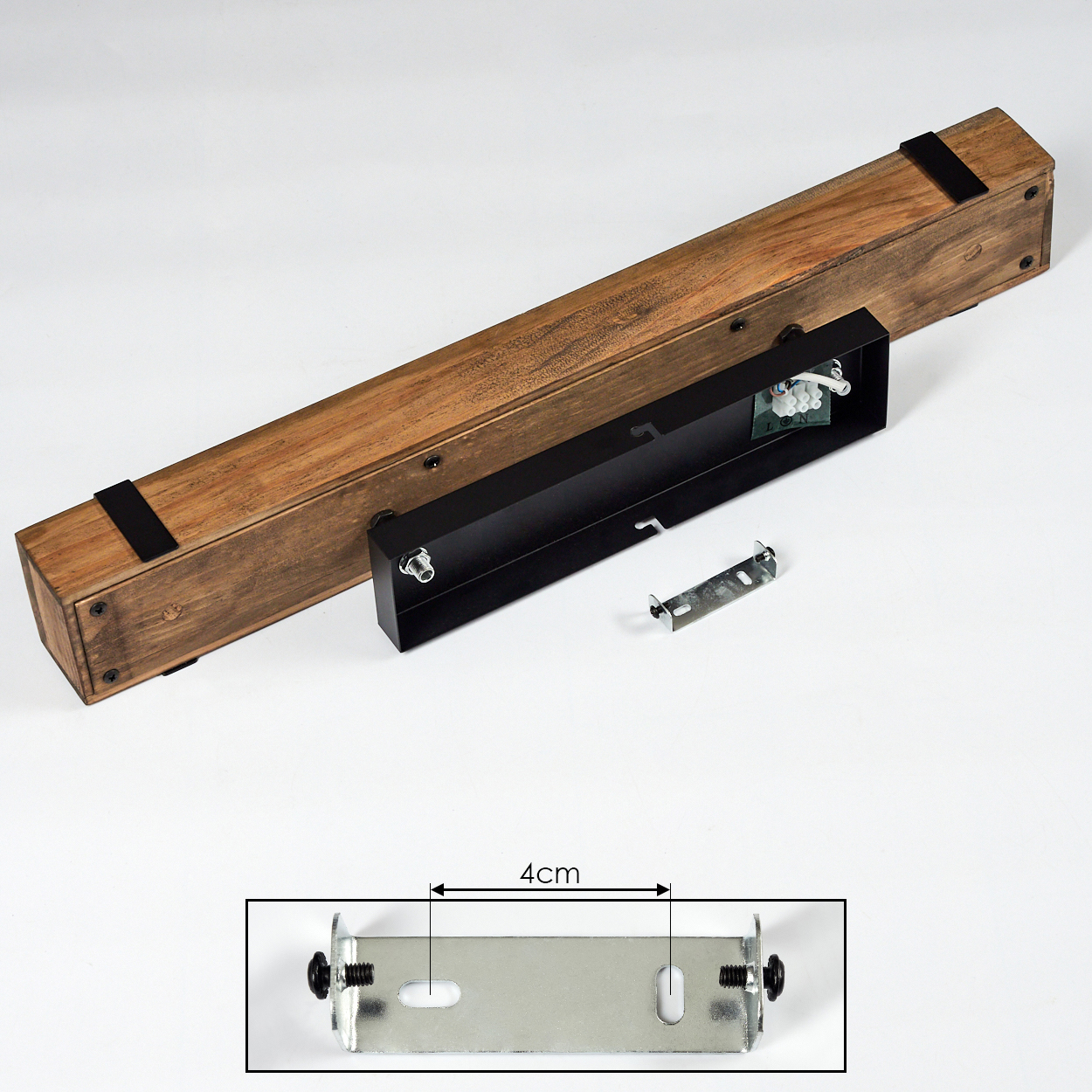 Holzleuchte mit schwarzen Metallkomponenten. Eine kleine Metallhalterung ist abgetrennt. Auf der Halterung ist ein Maß von 4 cm angegeben.
