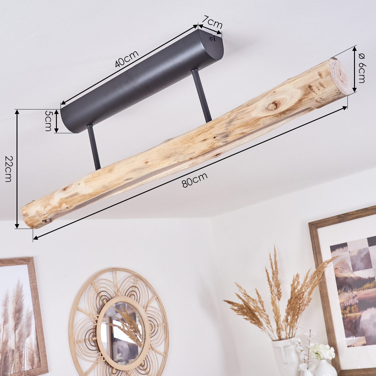 Eine Deckenlampe mit schwarzem Metallgestell und Holzbalken. Im Hintergrund Dekoration und gerahmte Bilder.
