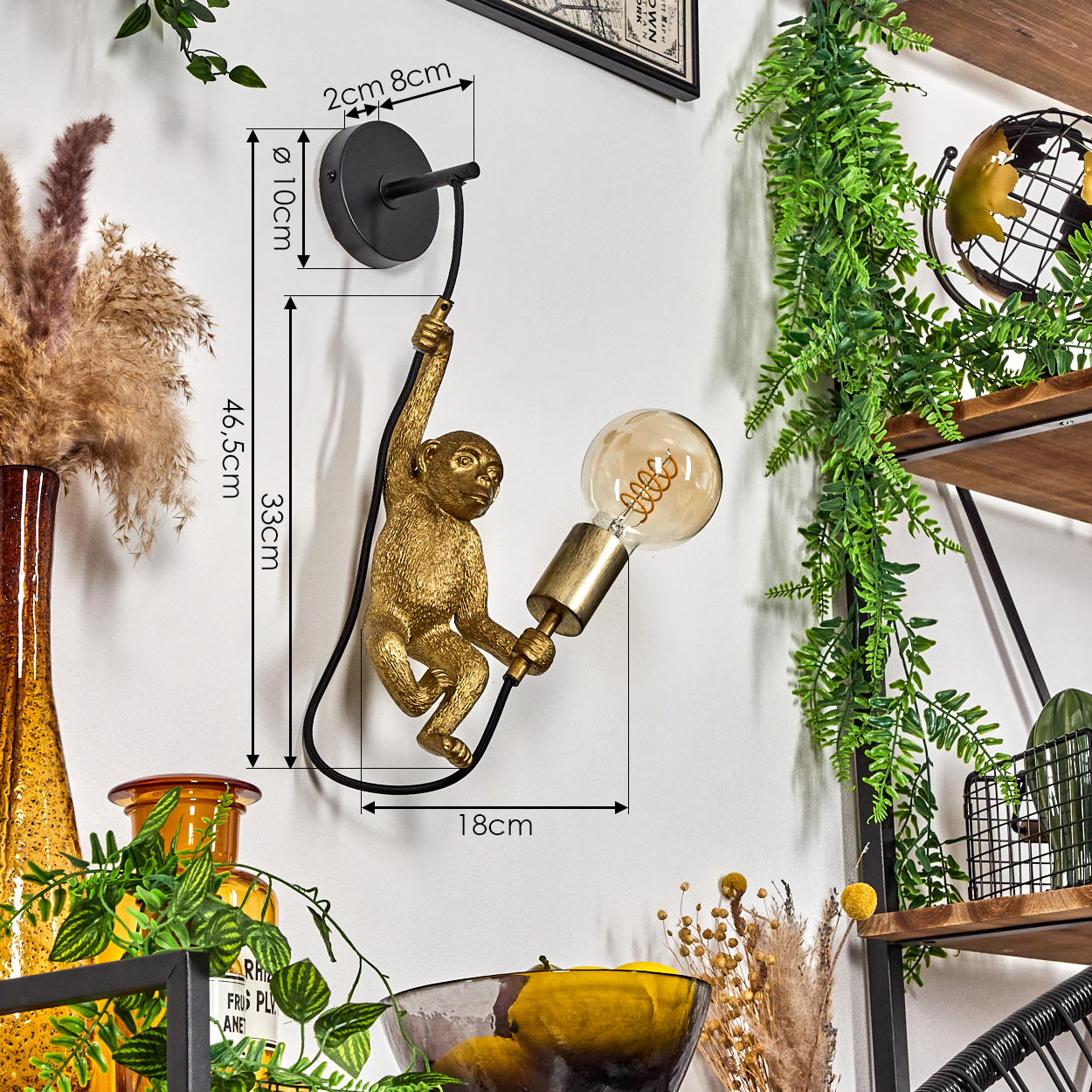 Goldene Affenlampe, die eine Glühbirne an einer weißen Wand hält. Grüne Pflanzen und Regale befinden sich im Hintergrund.