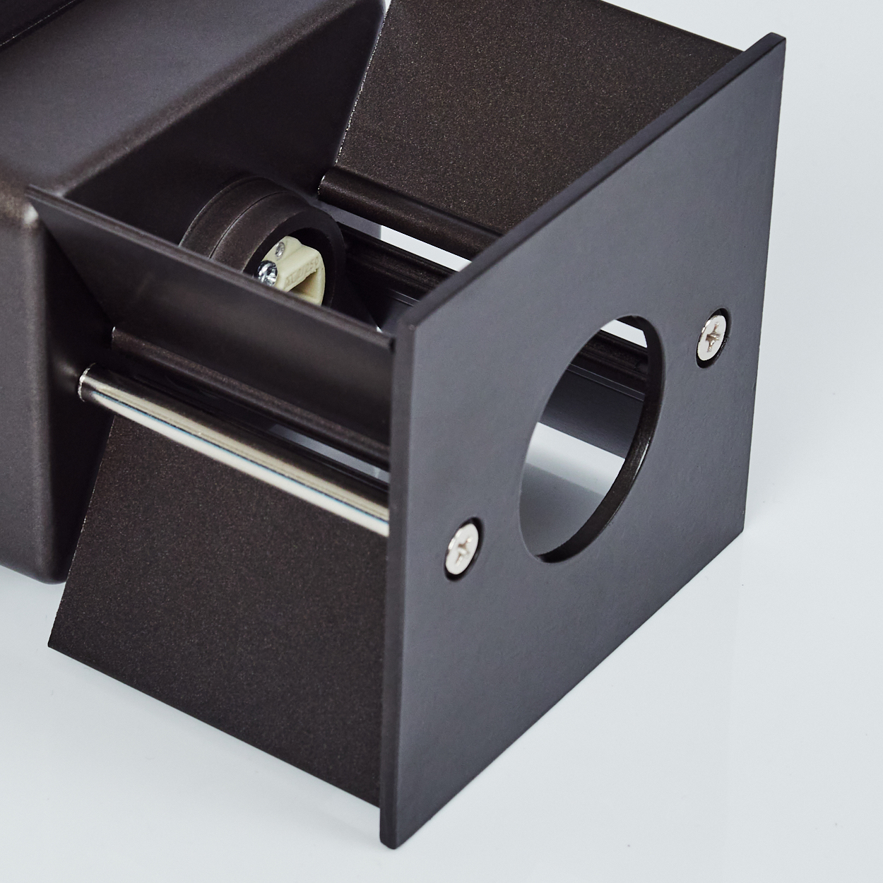 Nahaufnahme eines dunkelbraunen Metallobjekts mit rundem Loch, Schrauben und Silberstange. Der Hintergrund ist weiß.