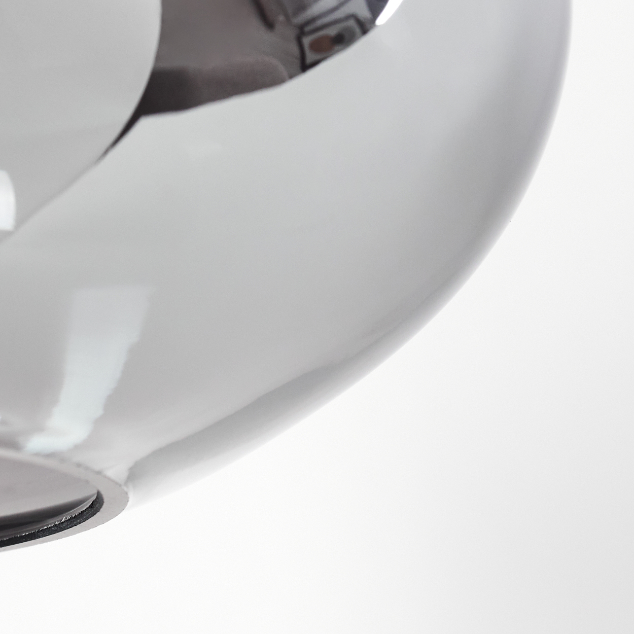 Nahaufnahme eines weißen, gebogenen, glänzenden Objekts mit reflektierender Oberfläche. Der Hintergrund ist schlicht weiß.