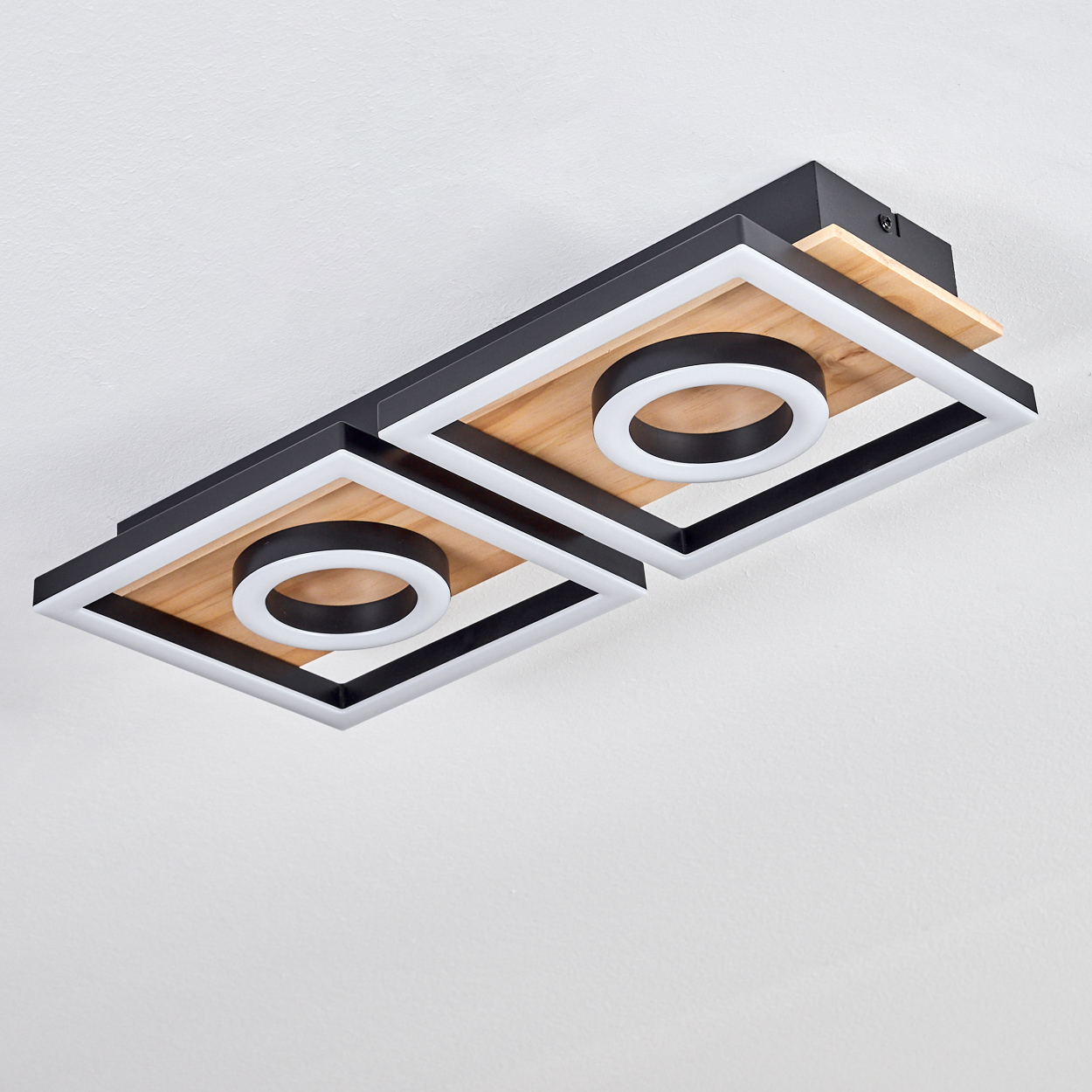 Moderne Deckenleuchte mit zwei quadratischen Holzrahmen, schwarzen Rändern und weißen LED-Ringen an einer weißen Decke.