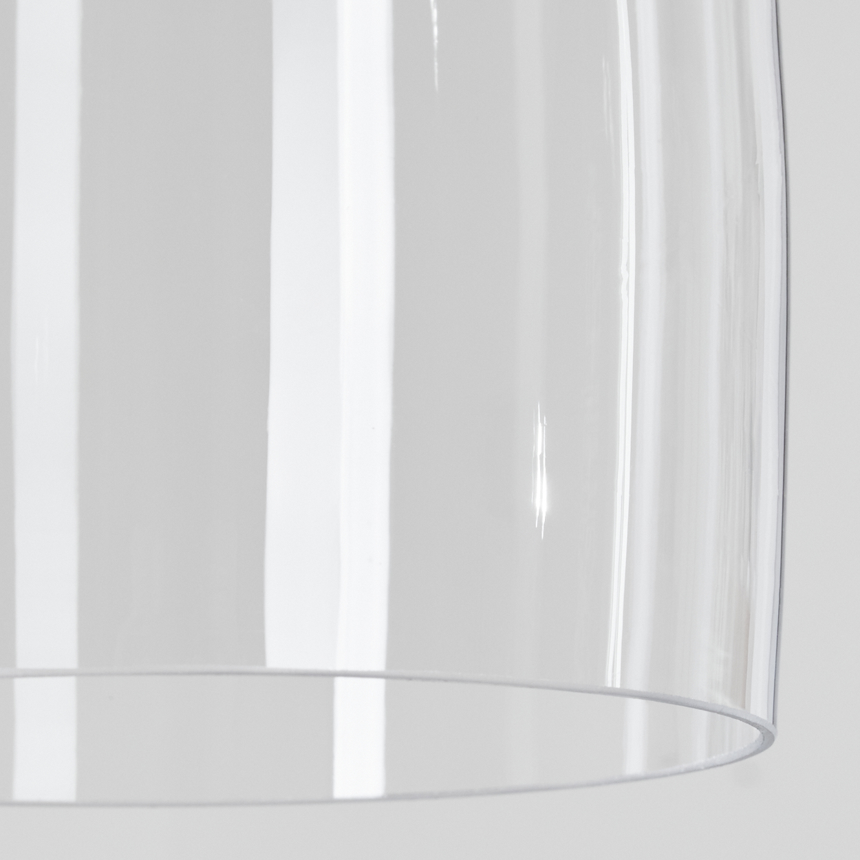 Nahaufnahme eines durchsichtigen Glasschirmes. Vertikale weiße Linien reflektieren das Licht. Ein dünner weißer Rand ist zu sehen.