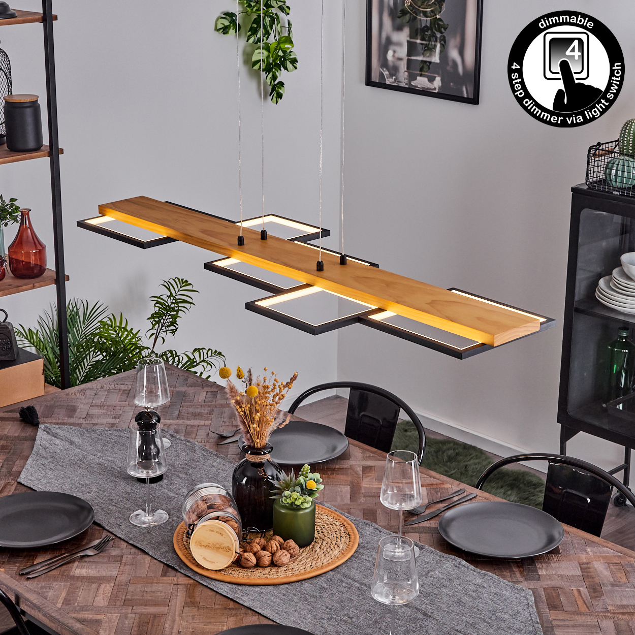 Ein Esszimmer mit Holztisch. Eine moderne Hängelampe hängt darüber. Teller, Gläser und Dekorationen stehen auf dem Tisch.