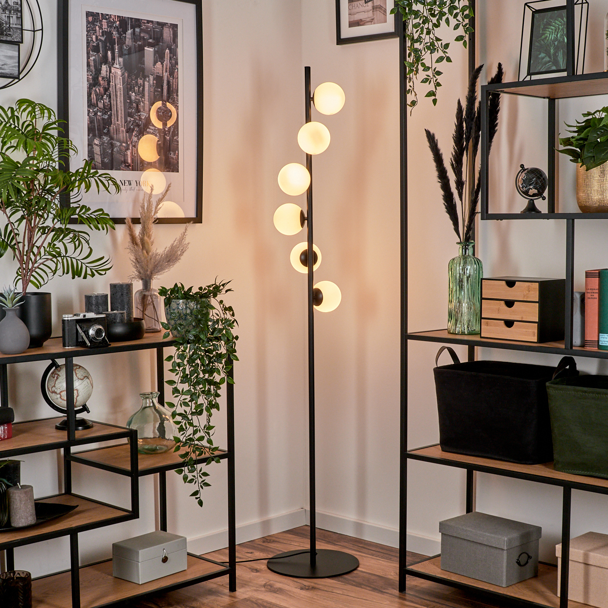 Ein modernes Wohnzimmer mit Stehlampe, Regalen, Pflanzen und einem Bild der Skyline von New York City.