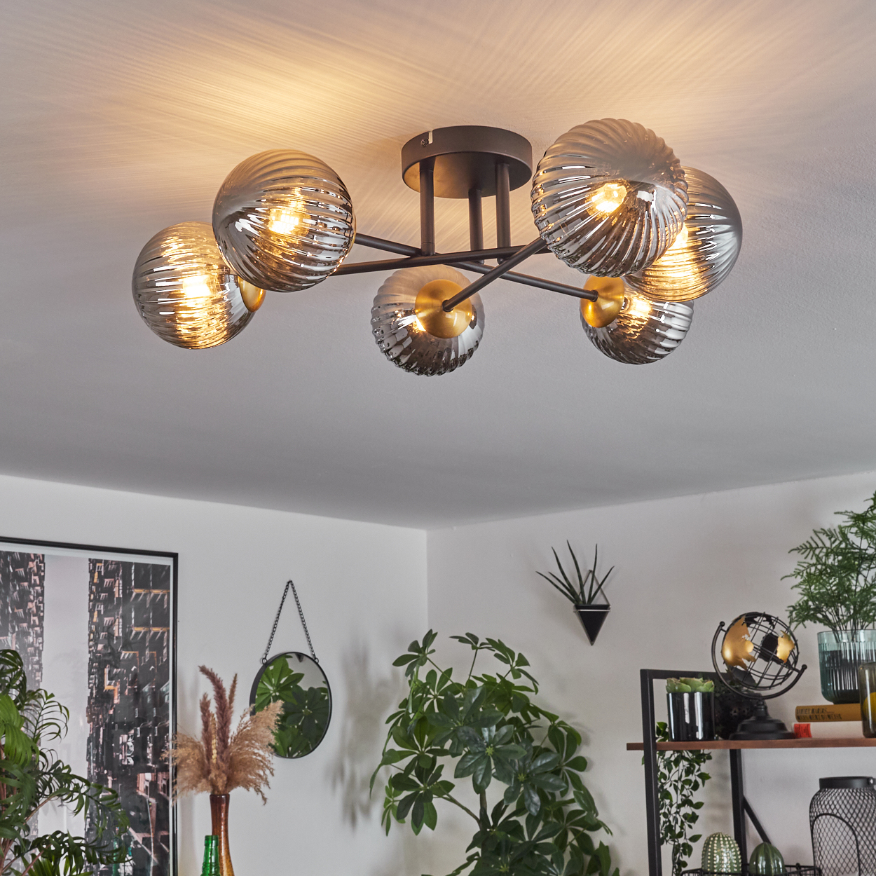 Moderne Deckenleuchte mit sechs kugelförmigen Lampen. Raumdekor umfasst Pflanzen, einen Spiegel und einen Bilderrahmen.