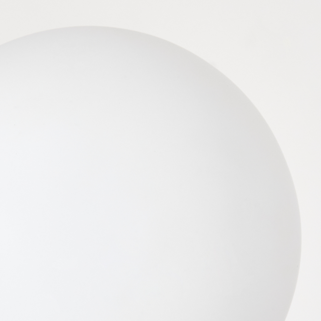 Ein weißes, abgerundetes Objekt, möglicherweise eine Kugel oder eine Lampe, vor weißem Hintergrund. Weicher Schatten deutet auf Beleuchtung hin.