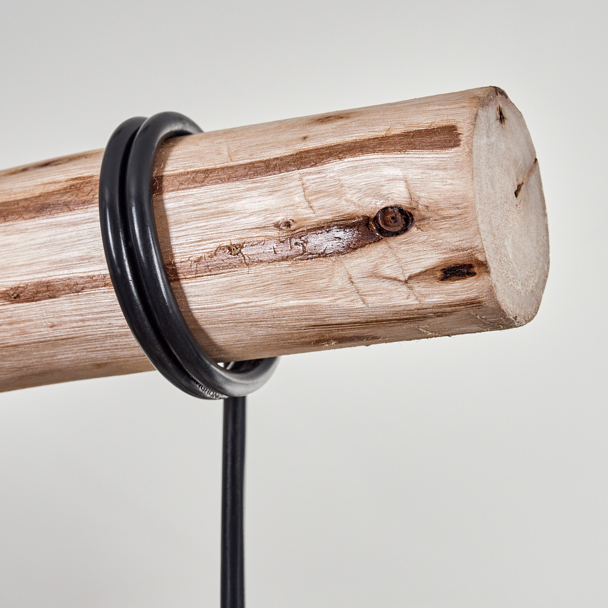 Ein Holzstamm mit einem schwarzen Kabel darum gewickelt. Der Stamm ist hellbraun, das Kabel schwarz. Der Hintergrund ist weiß.