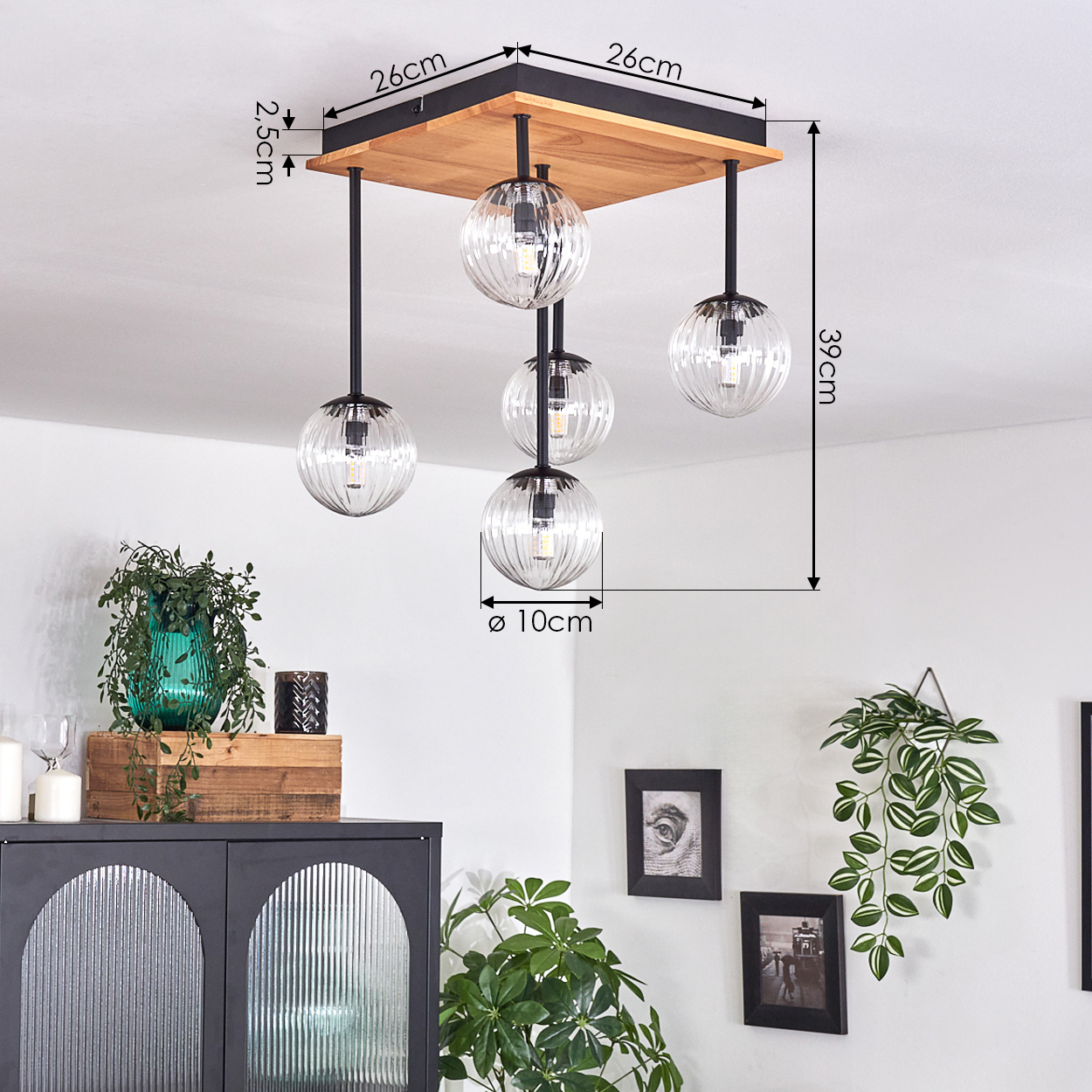 Eine moderne Deckenleuchte mit fünf Glaskugelleuchten hängt von einer Holzdecke ab. Abmessungen und Details sind angegeben.