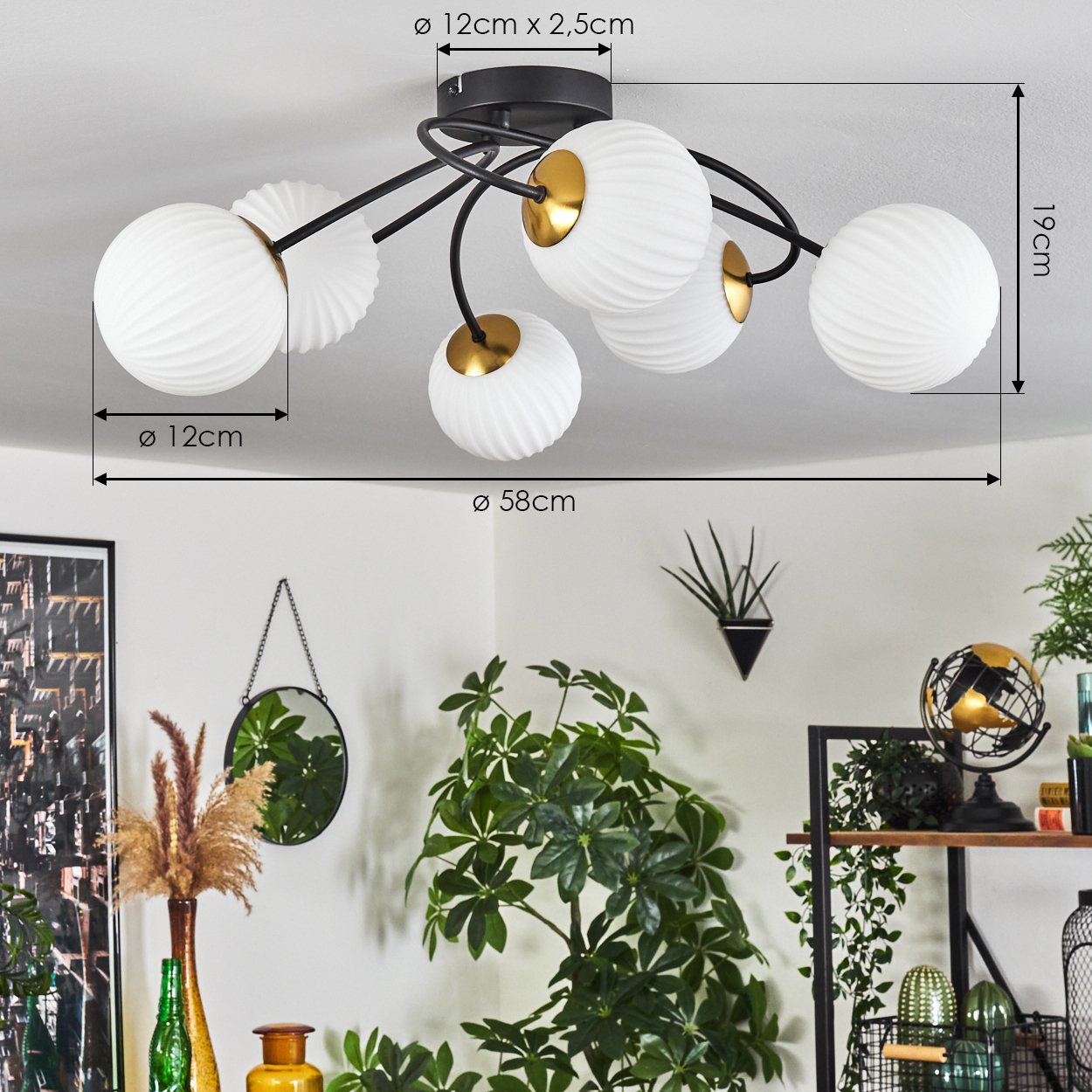 Eine Deckenlampe mit weißen, kugelförmigen Lampenschirmen und schwarzen Armen. Der Hintergrund zeigt Pflanzen, einen Spiegel und andere Dekorationsartikel.