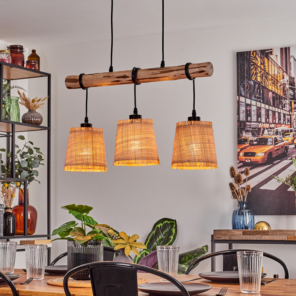 Ein Esszimmer mit Holztisch, schwarzen Stühlen und einer Leuchte mit drei Lampenschirmen. An der Wand hängt ein Gemälde von New York.