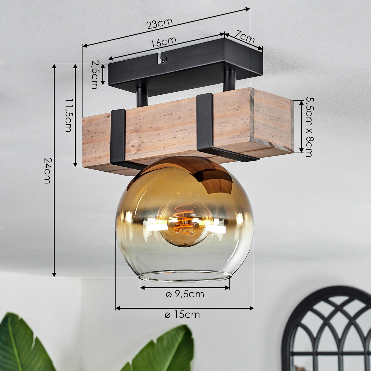 Deckenlampe mit Holzbalken, schwarzen Metallstützen und einer goldenen Glaskugel. Maße sind in Zentimetern angegeben.