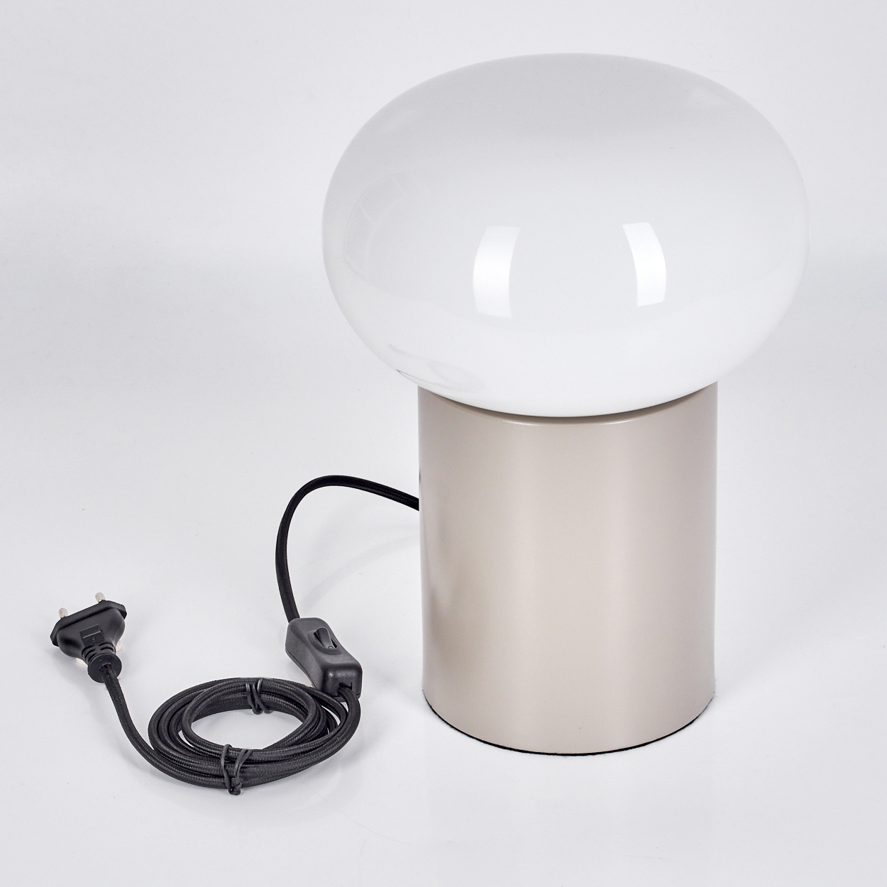 Eine pilzförmige Lampe mit weißer Kugel auf beigefarbenem zylindrischen Sockel. Ein schwarzes Kabel mit Stecker erstreckt sich nach links.
